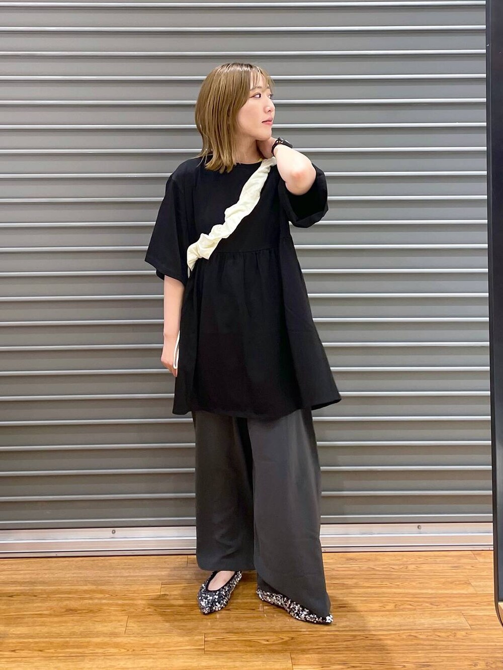 ホワイト系のショルダーバッグ、グレー系のその他パンツ、シルバー系のパンプスを着用したレディースの夏コーディネートの3枚目の写真