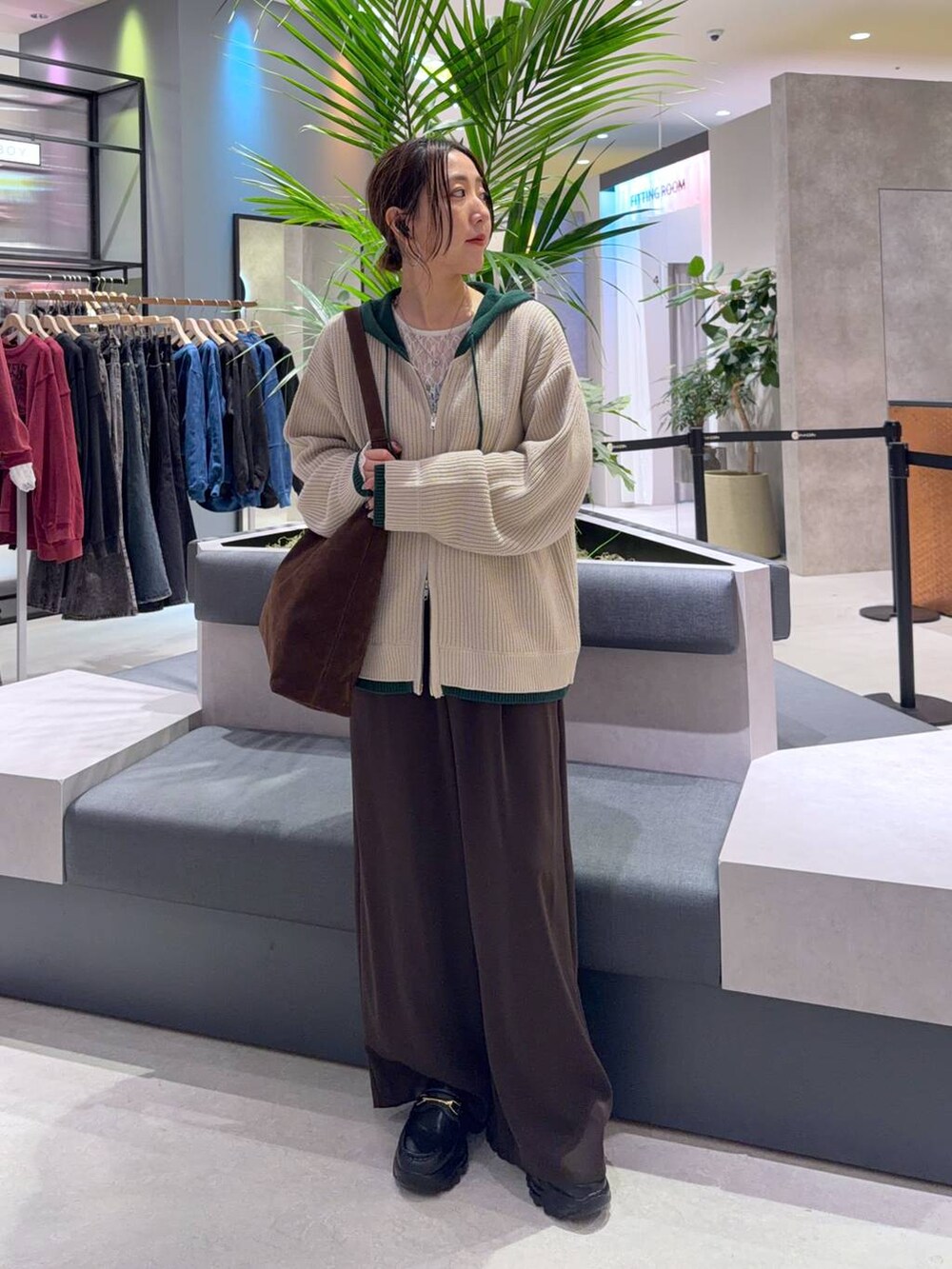 ブラウン系のショルダーバッグ、ブラウン系のスラックス、ホワイト系のTシャツ/カットソーを着用したレディースの秋コーディネートの3枚目の写真