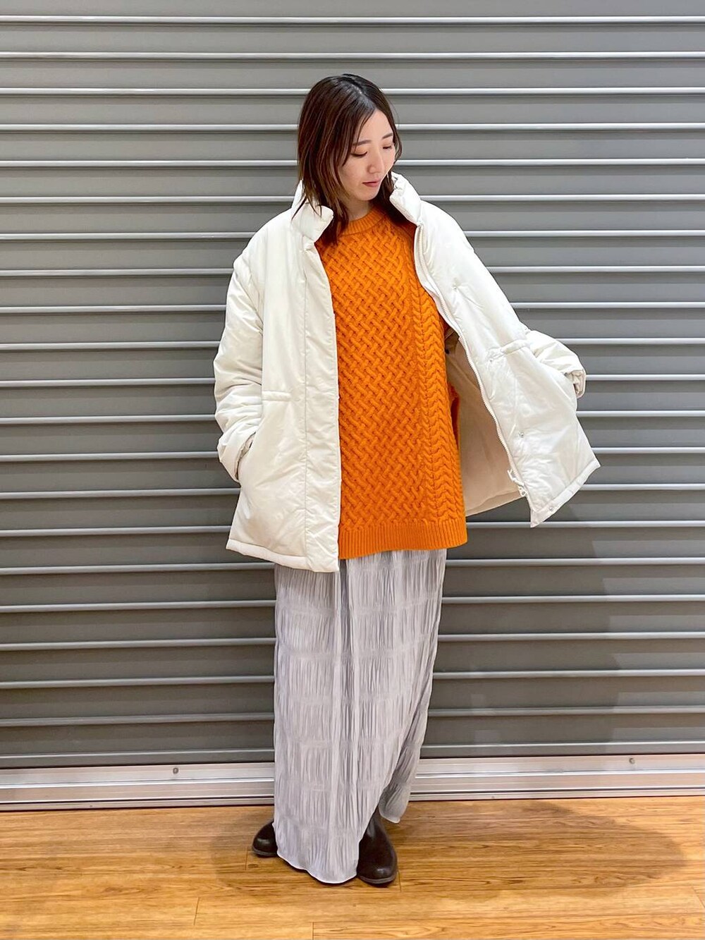 ホワイト系のその他アウター、ブラウン系のブーツ、オレンジ系のその他トップスを着用したレディースの冬コーディネートの2枚目の写真