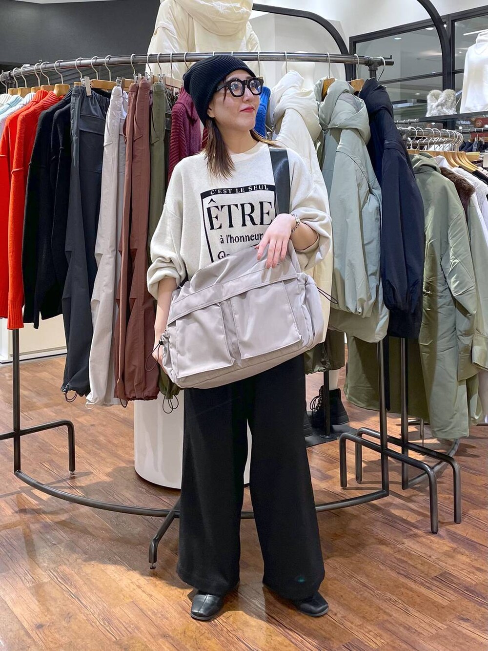 ホワイト系のニット/セーター、ブラック系のその他パンツ、グレー系のショルダーバッグを着用したレディースの冬コーディネートの3枚目の写真