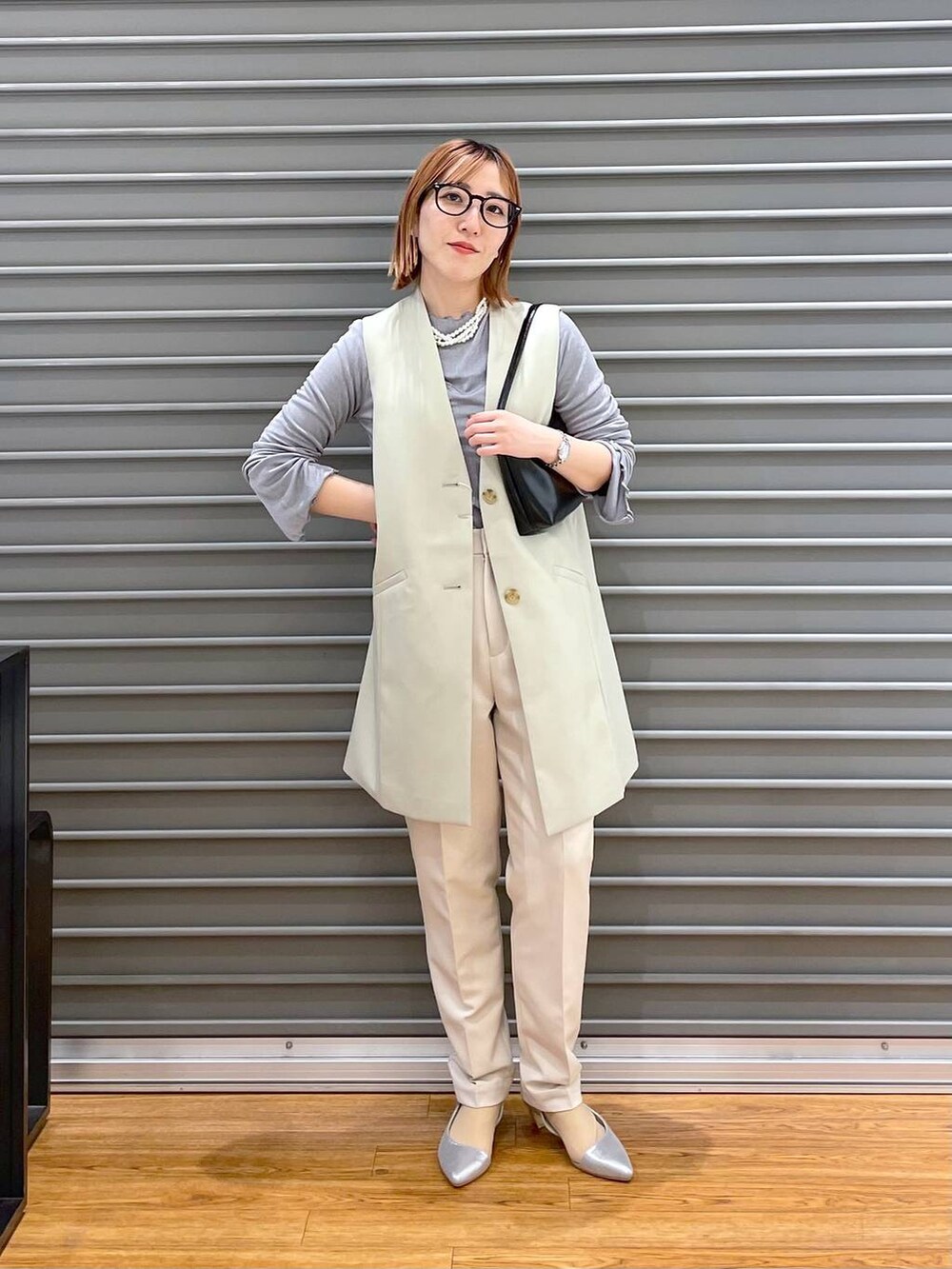 グレー系のTシャツ/カットソー、ブラック系のハンドバッグ、ホワイト系のその他パンツを着用したレディースの冬コーディネートの2枚目の写真