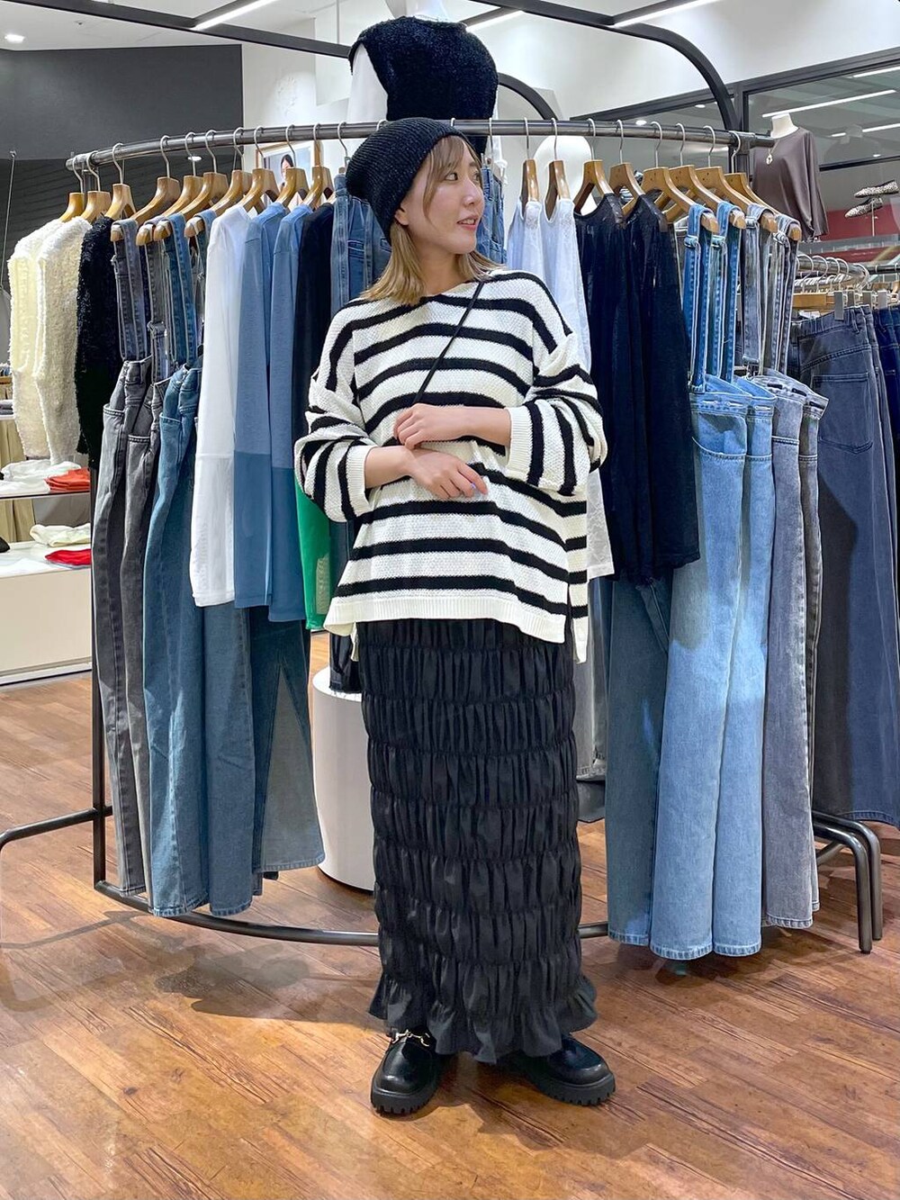 ブラック系のスカート、ブラック系のニット/セーター、ブラック系のショルダーバッグを着用したレディースの秋コーディネートの2枚目の写真