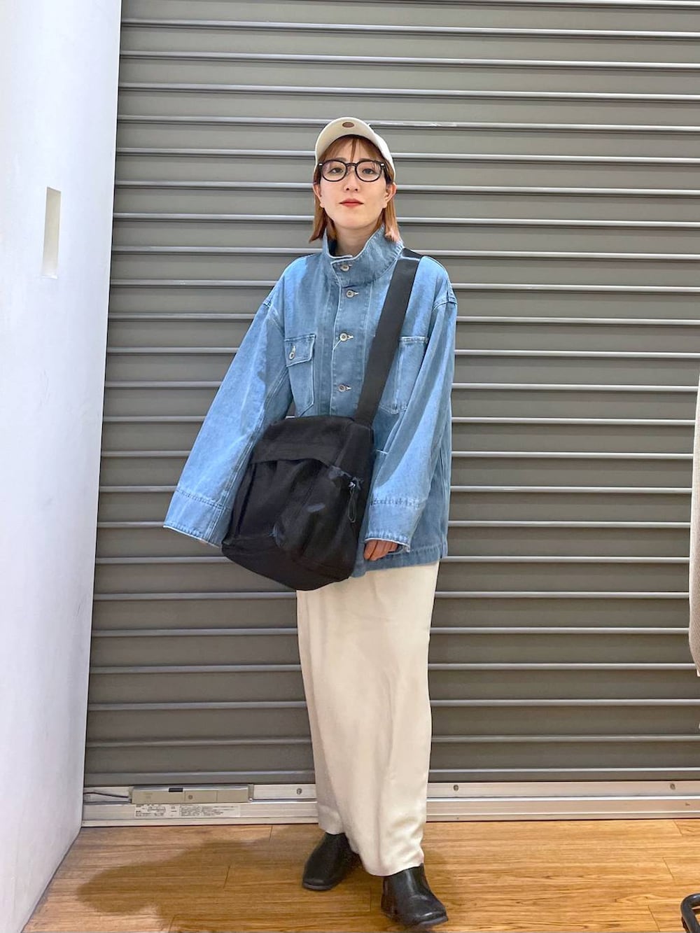 ホワイト系のスカート、ブラック系のショルダーバッグ、ブルー系のデニムジャケットを着用したレディースの春コーディネートの2枚目の写真