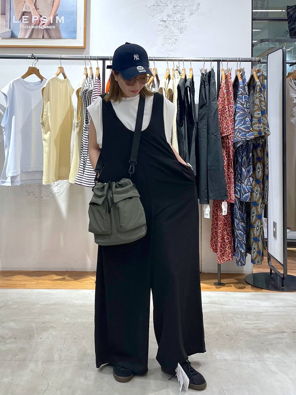 ホワイト系のTシャツ/カットソー、グリーン系のショルダーバッグ、ブラック系のサロペット/オーバーオールを着用したレディースの夏コーディネートの2枚目の写真