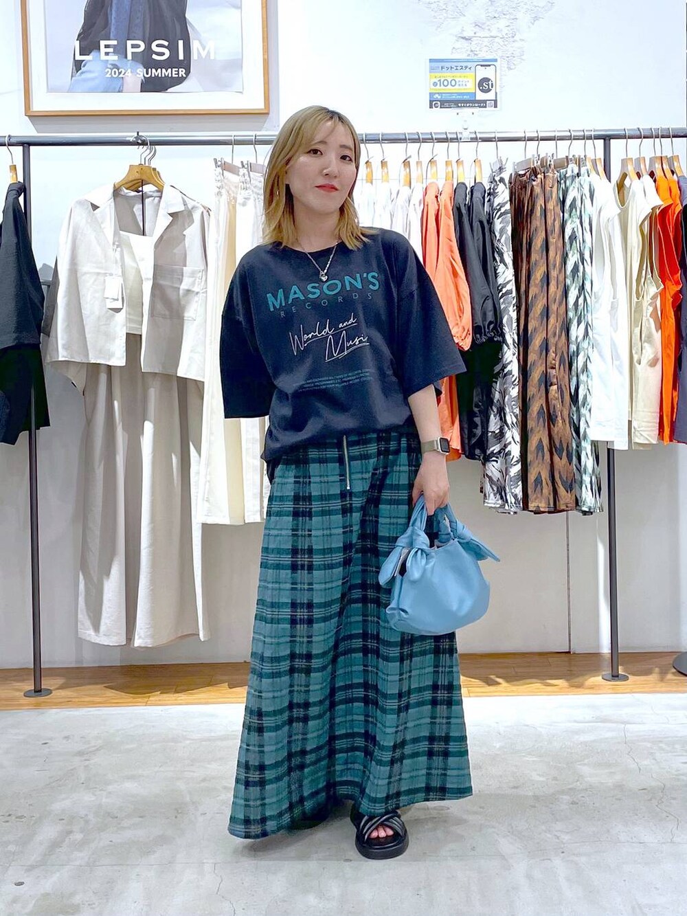 グレー系のTシャツ/カットソー、シルバー系のサンダル、ブルー系のショルダーバッグを着用したレディースの夏コーディネートの2枚目の写真