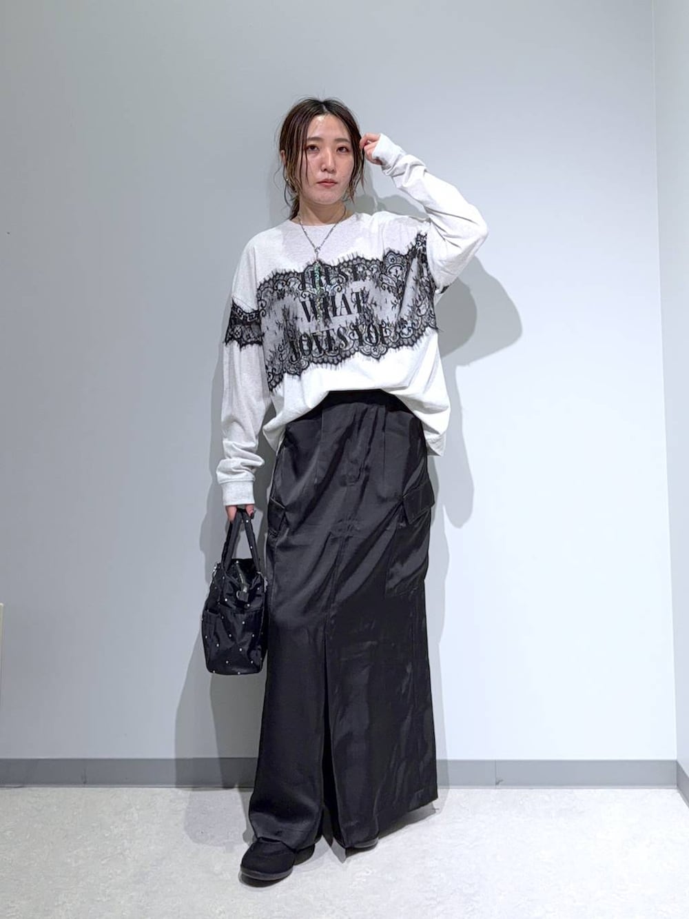 ブラック系のパンプス、ブラック系のスカート、グレー系のTシャツ/カットソーを着用したレディースの夏コーディネートの2枚目の写真