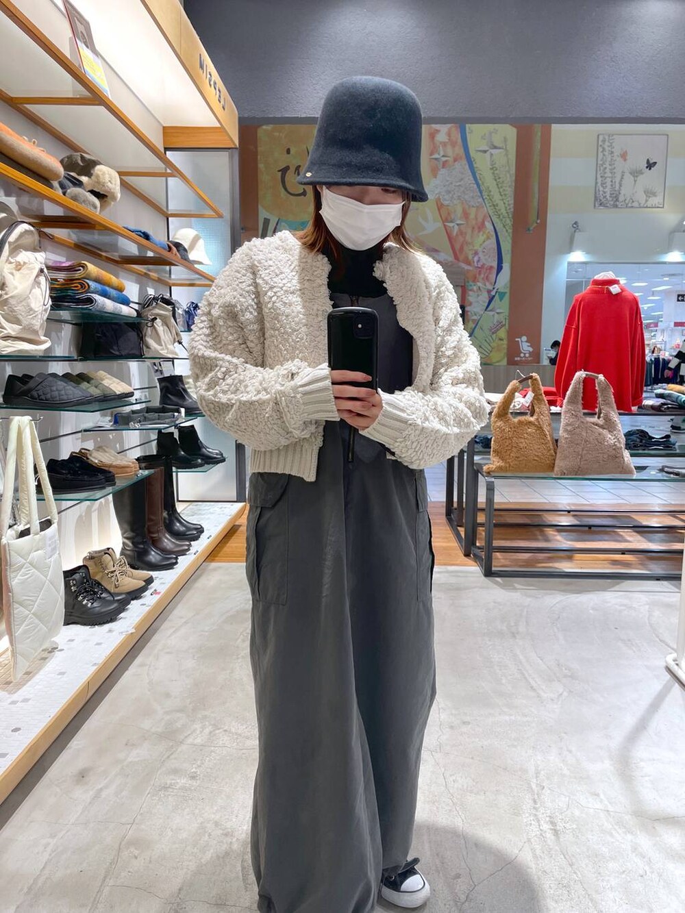 ブラック系のニット/セーター、グレー系のジャンパースカート、グレー系のカーディガン/ボレロを着用したレディースの冬コーディネートの2枚目の写真