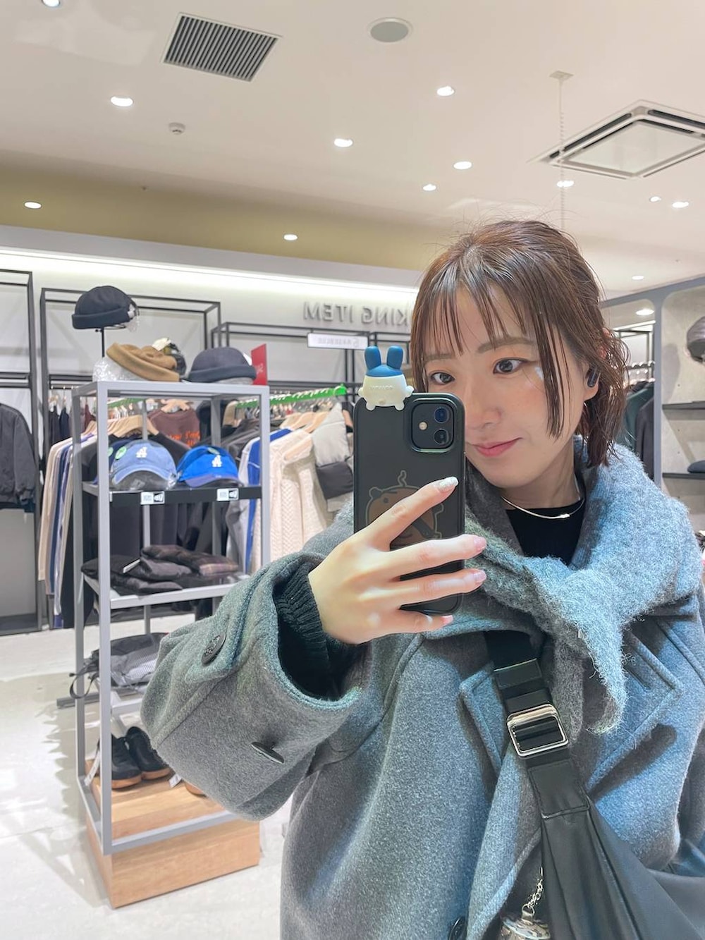 グレー系のピーコート、グレー系のスウェットパンツ、グレー系のストール/ショールを着用したレディースの冬コーディネートの2枚目の写真