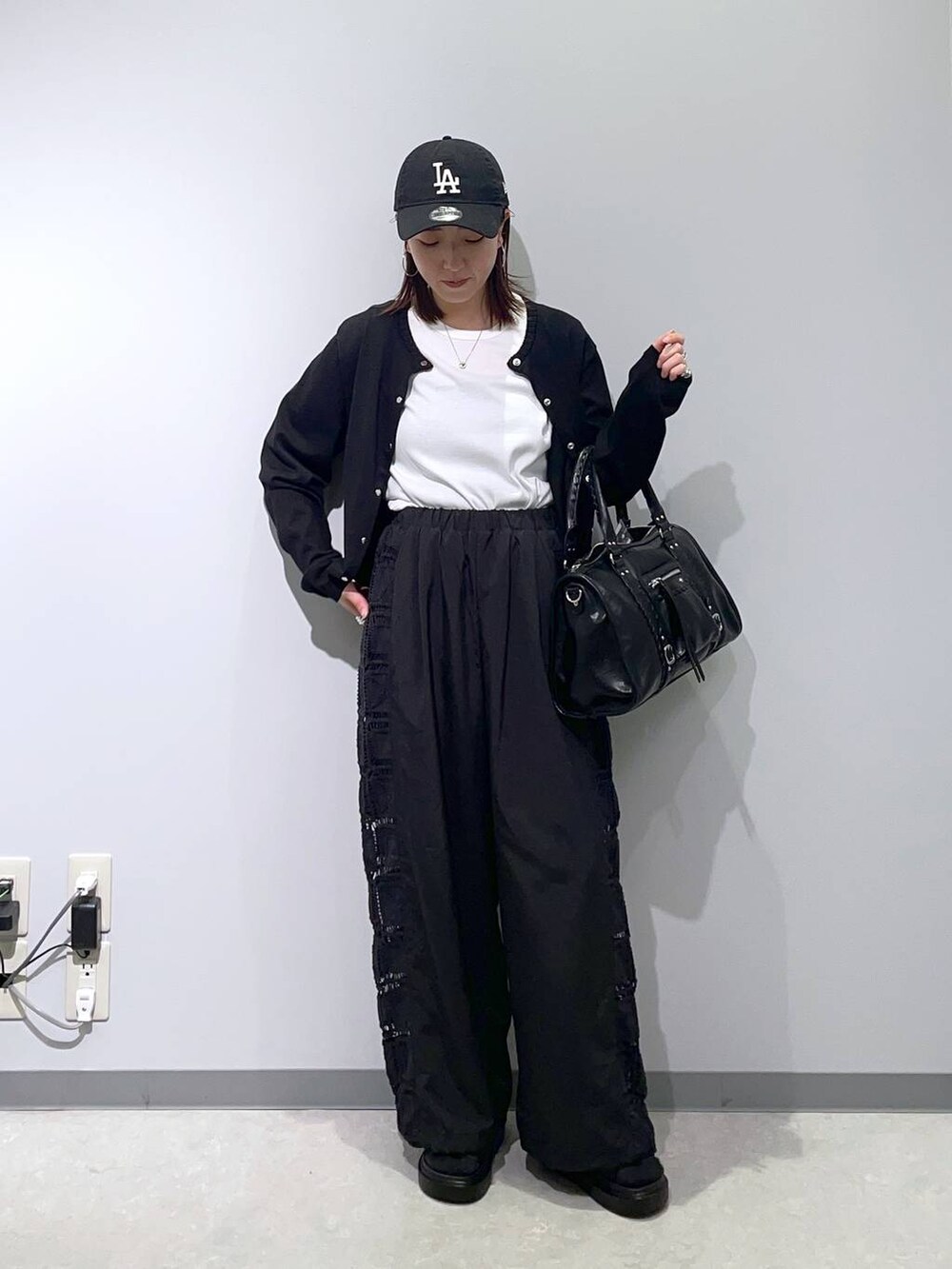 ブラック系のその他パンツ、ブラック系のサンダル、ブラック系のボストンバッグを着用したレディースの春コーディネートの2枚目の写真