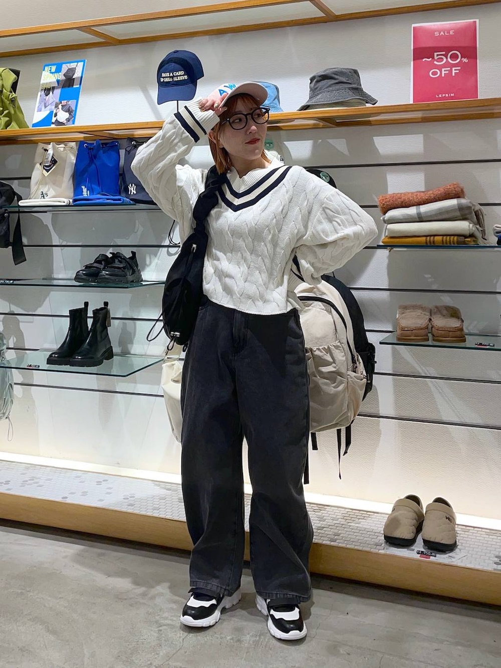 ホワイト系のニット/セーター、ブラック系のデニムパンツ、ホワイト系のスニーカーを着用したレディースの冬コーディネートの2枚目の写真