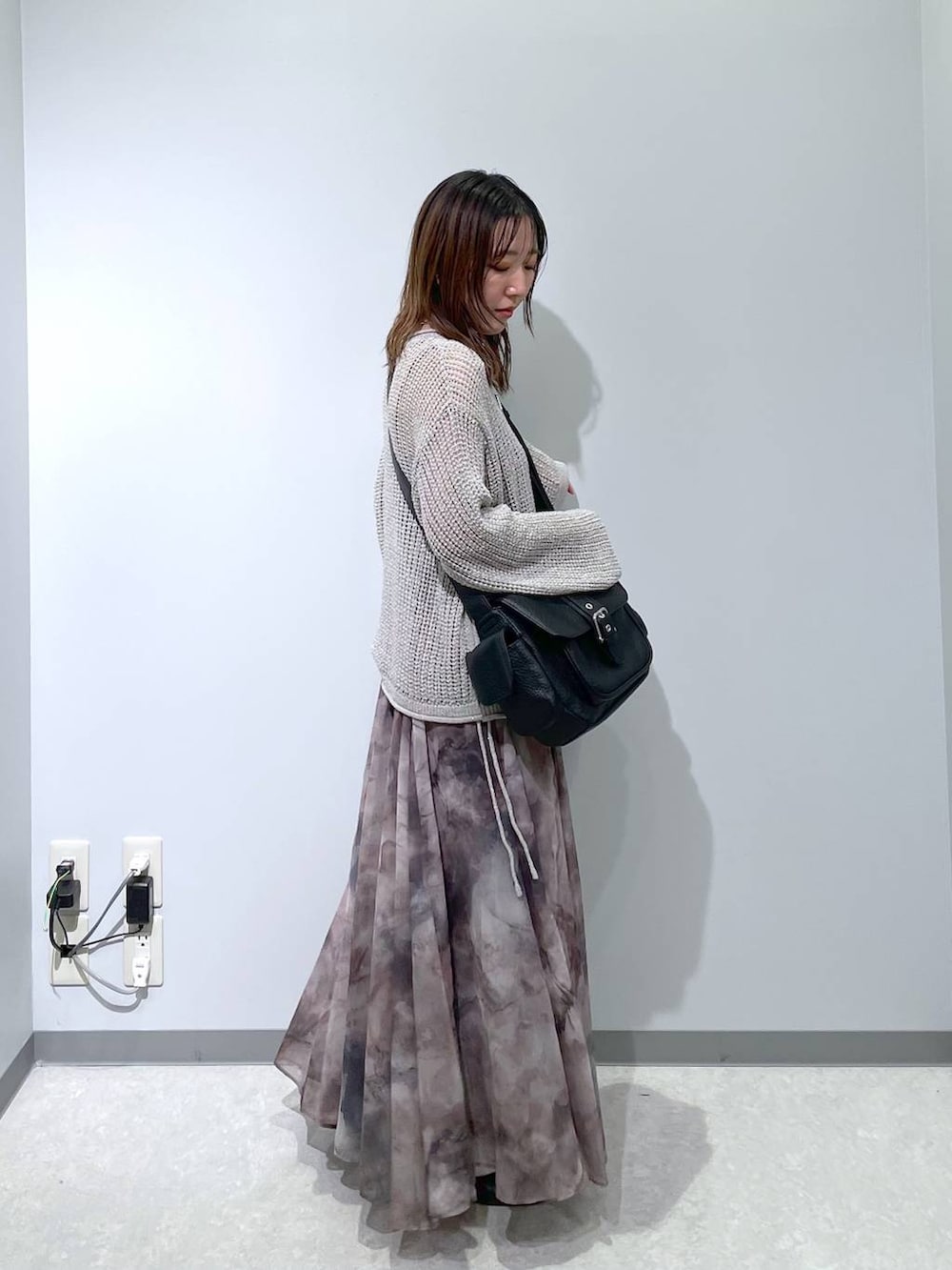 ブラック系のショルダーバッグ、グレー系のスカート、グレー系のニット/セーターを着用したレディースの春コーディネートの3枚目の写真