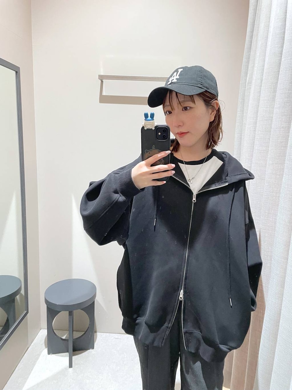 ブラック系のパーカー、ブラック系のキャップを着用したレディースの冬コーディネートの3枚目の写真