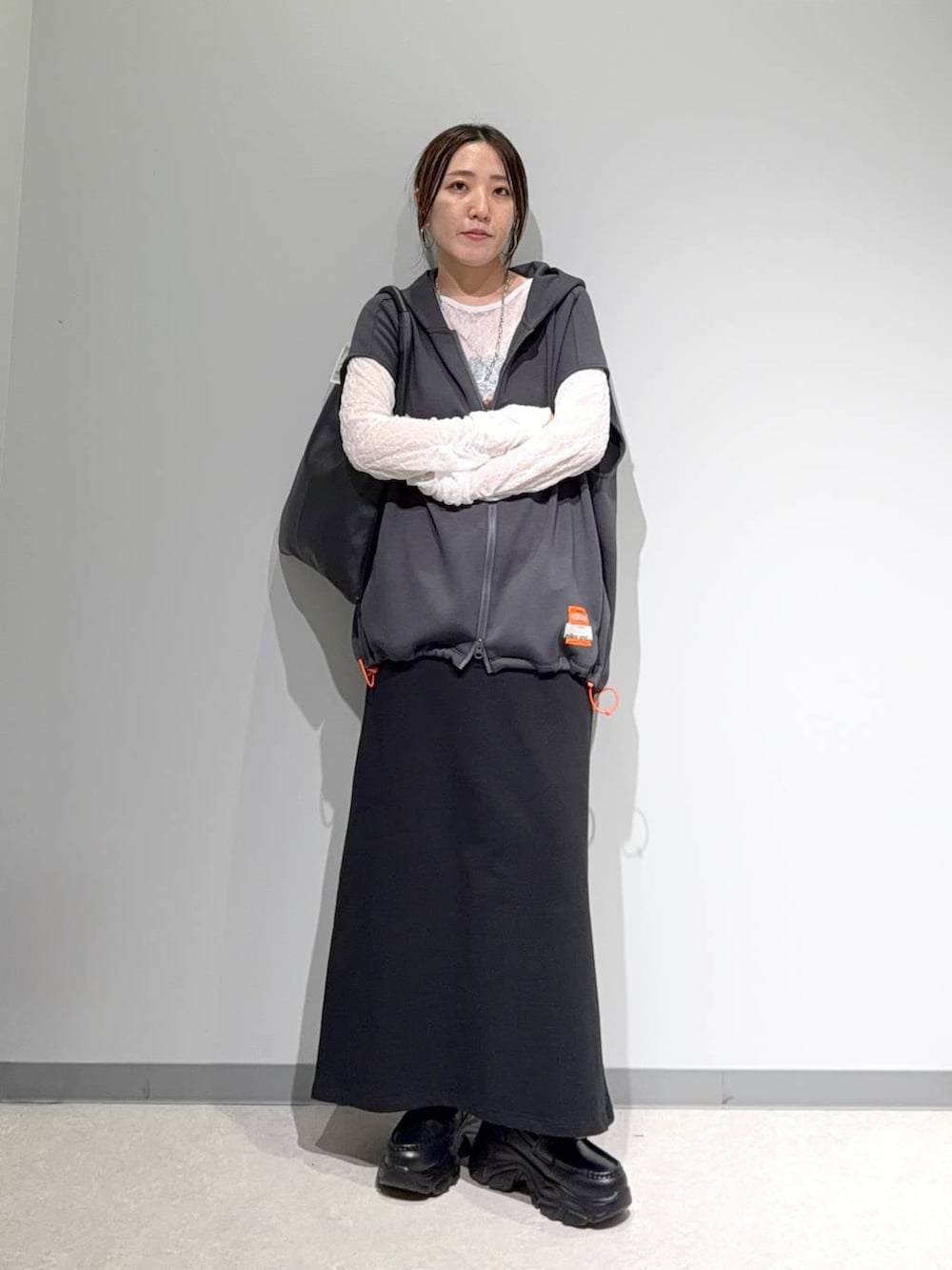 グレー系のベスト、ホワイト系のTシャツ/カットソー、ブラック系のスカートを着用したレディースの夏コーディネートの2枚目の写真