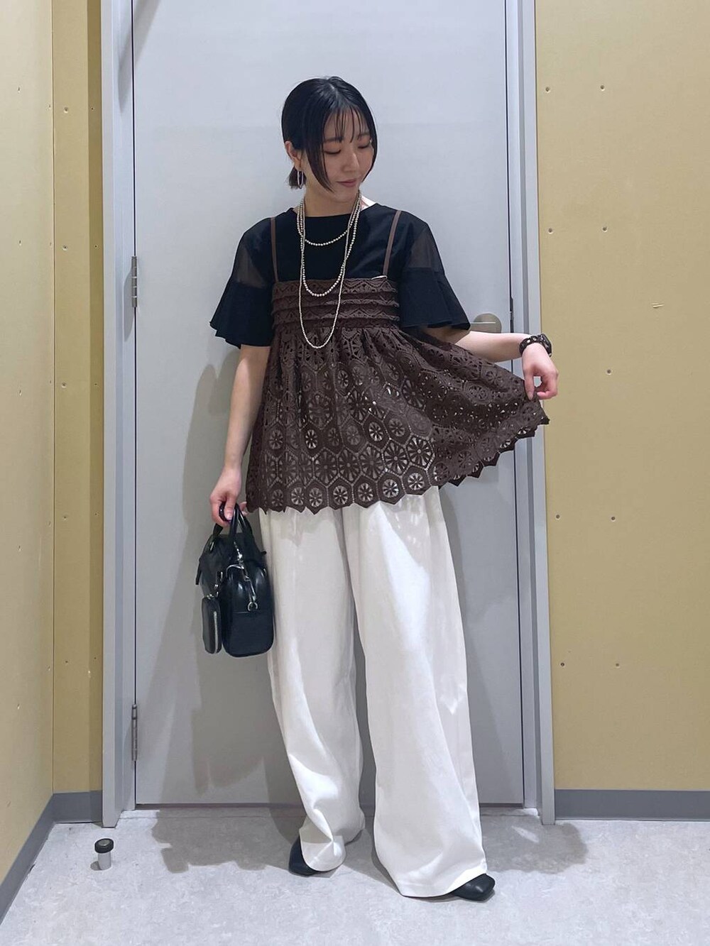 ブラック系のTシャツ/カットソー、ブラウン系のキャミソール、ブラック系のショルダーバッグを着用したレディースの夏コーディネートの4枚目の写真