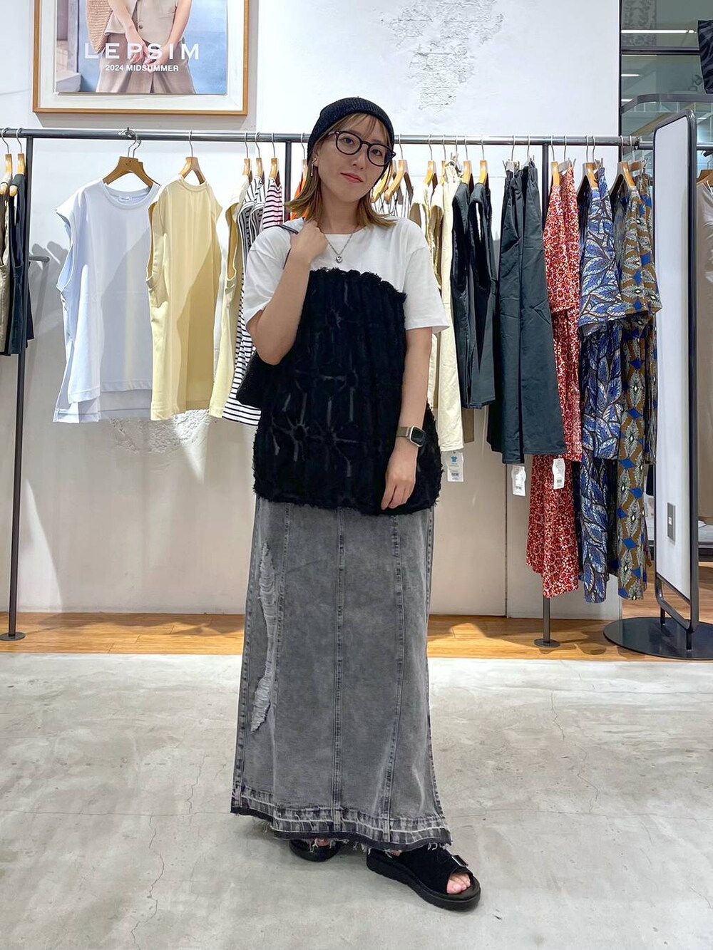 ブラック系のショルダーバッグ、ホワイト系のTシャツ/カットソー、ブラック系のサンダルを着用したレディースの夏コーディネートの2枚目の写真