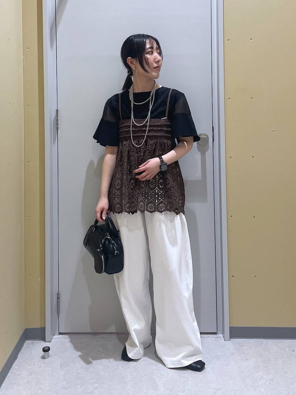 ブラック系のTシャツ/カットソー、ブラウン系のキャミソール、ブラック系のショルダーバッグを着用したレディースの夏コーディネートの3枚目の写真