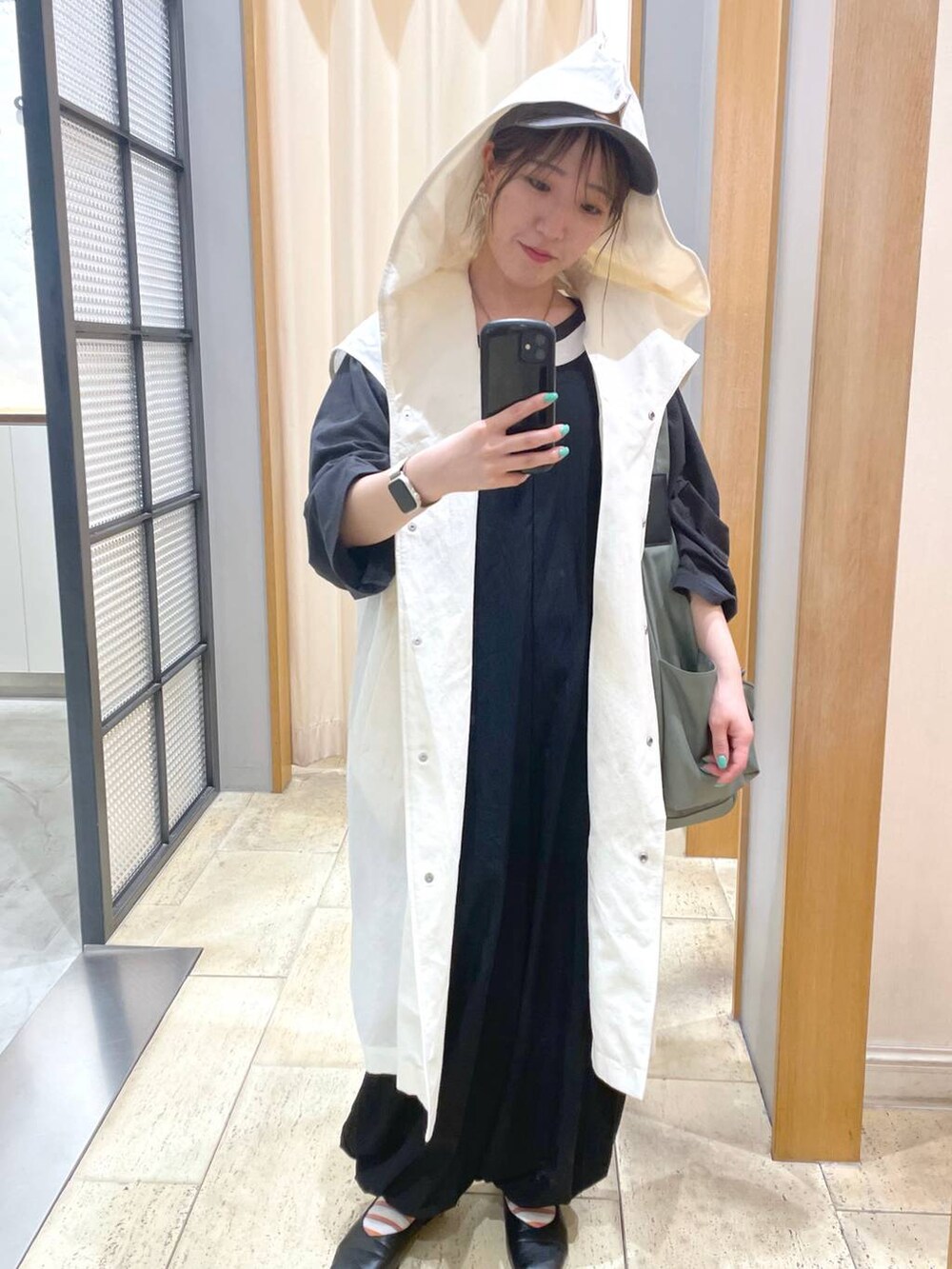 グリーン系のボディバッグ/ウエストポーチ、ブラック系のTシャツ/カットソー、ブラック系のサロペット/オーバーオールを着用したレディースの春コーディネートの2枚目の写真