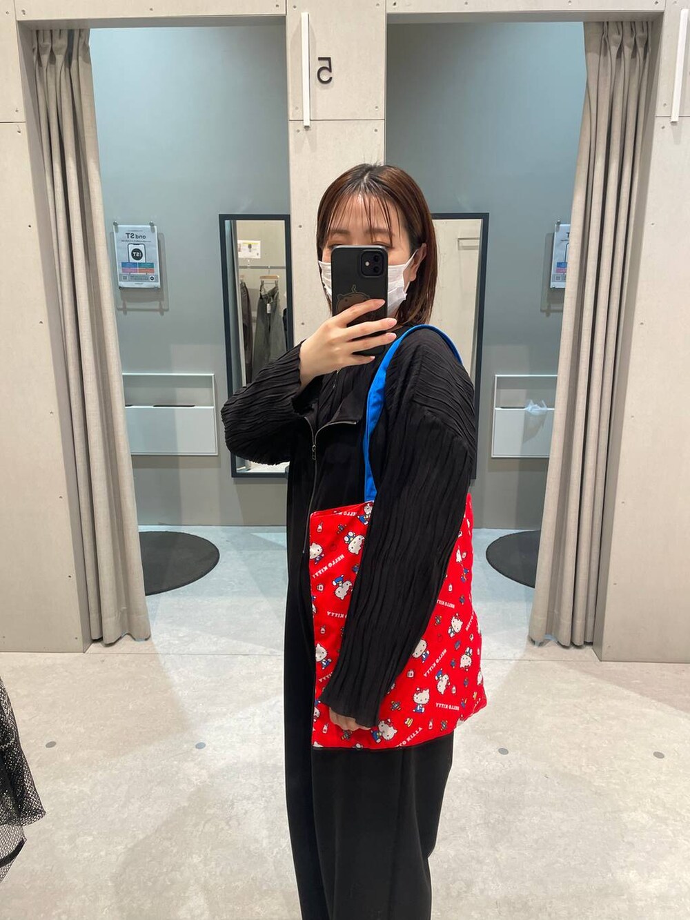 レッド系のトートバッグを着用したレディースの春コーディネートの2枚目の写真