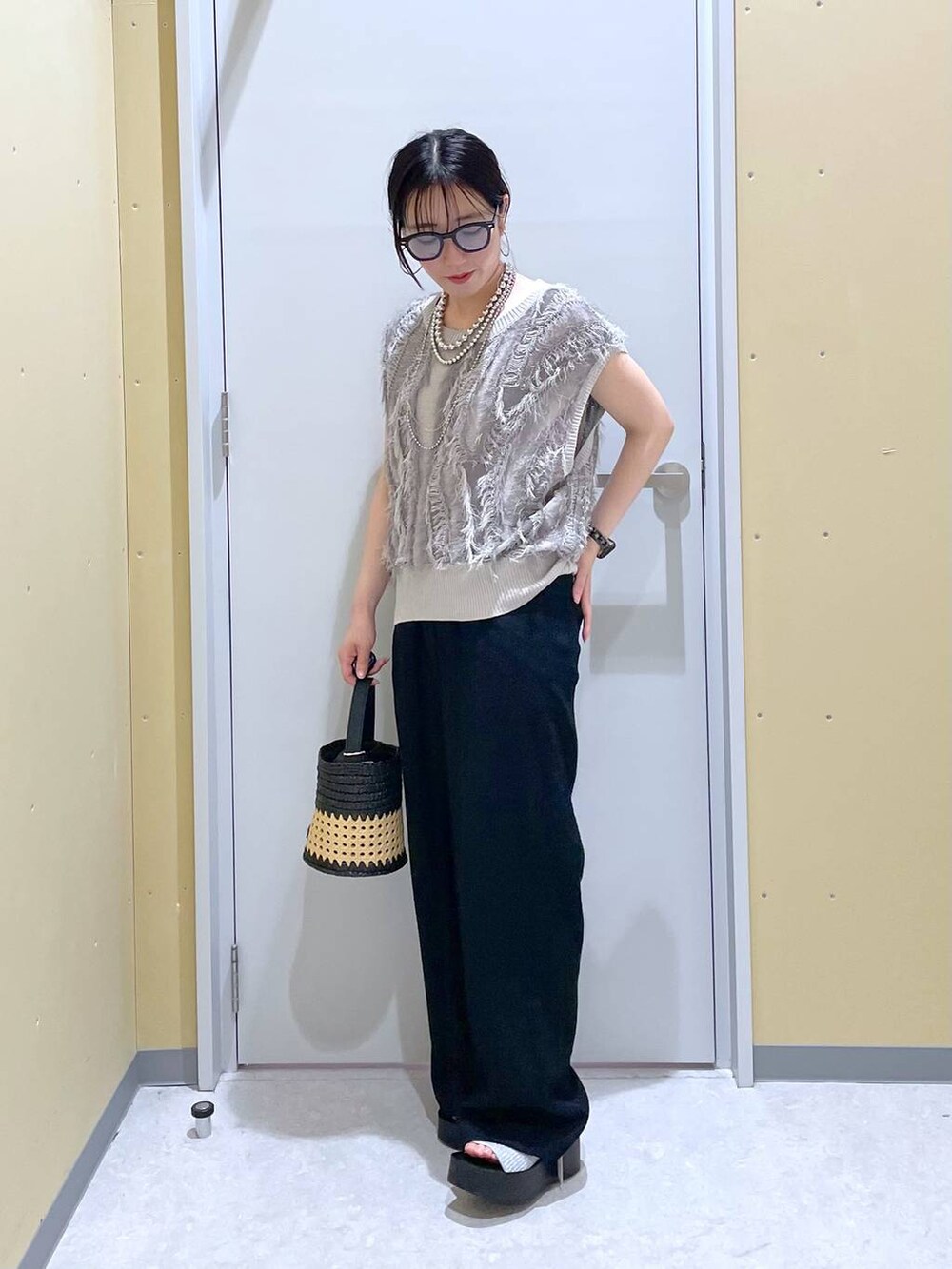 シルバー系のサンダル、ブラック系のショルダーバッグ、グレー系のニット/セーターを着用したレディースの夏コーディネートの2枚目の写真