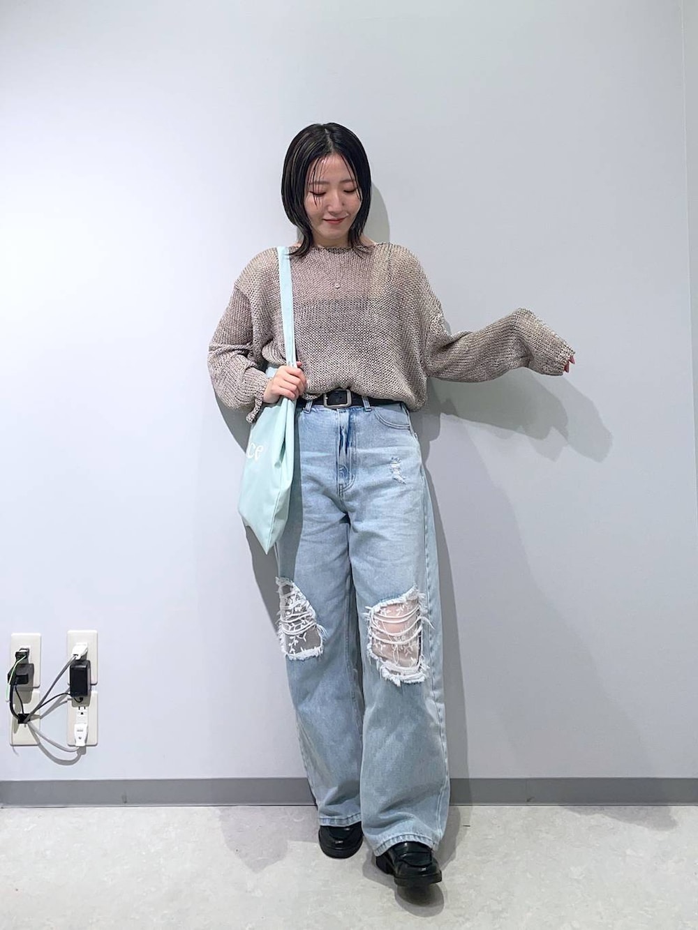 ブルー系のデニムパンツ、グレー系のニット/セーターを着用したレディースの春コーディネートの2枚目の写真