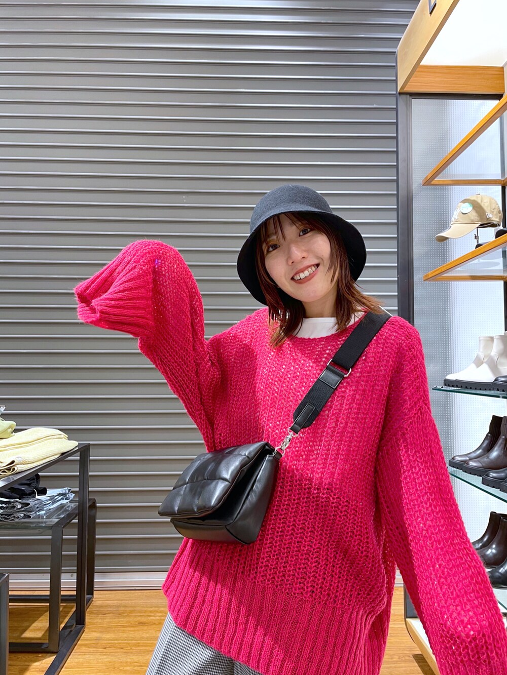 ピンク系のニット/セーター、ブラック系のショルダーバッグ、ホワイト系のTシャツ/カットソーを着用したレディースの秋コーディネートの3枚目の写真