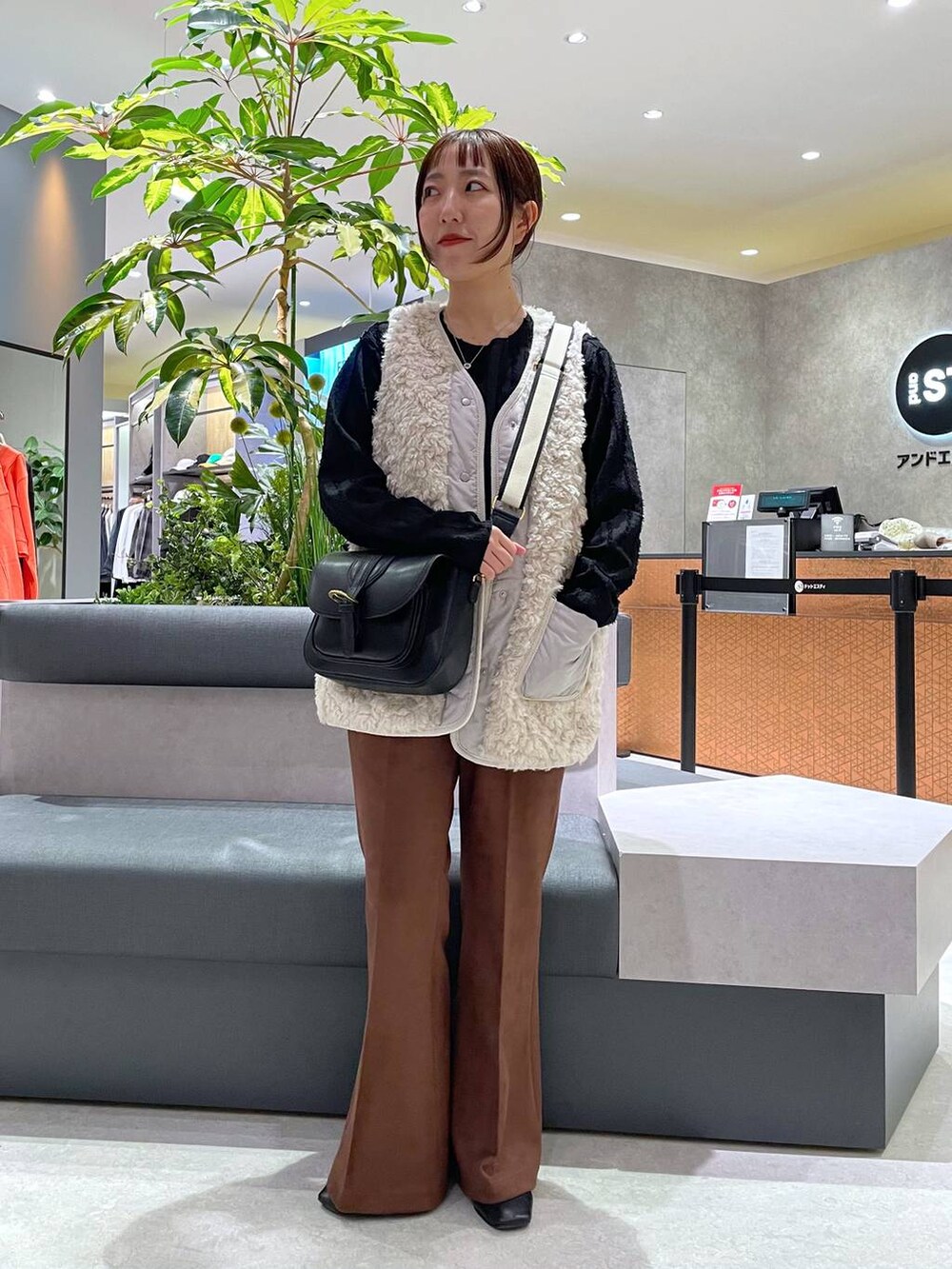 ブラック系のTシャツ/カットソー、ベージュ系のベスト、ブラック系のショルダーバッグを着用したレディースの秋コーディネートの2枚目の写真