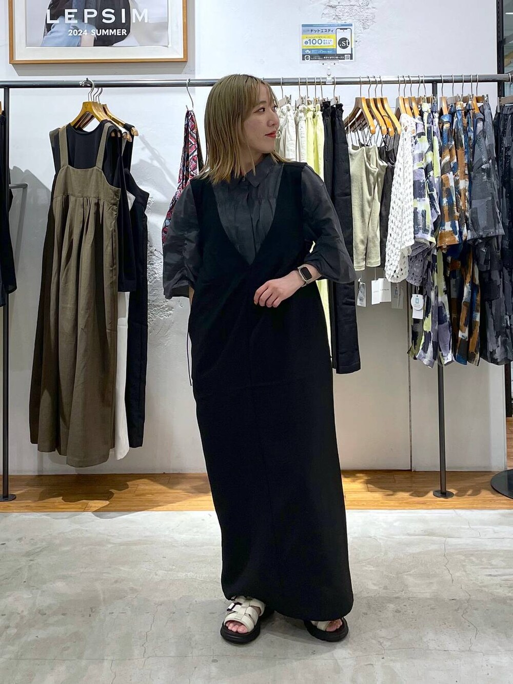 ブラック系のワンピース、ホワイト系のサンダル、グレー系のシャツ/ブラウスを着用したレディースの夏コーディネートの2枚目の写真