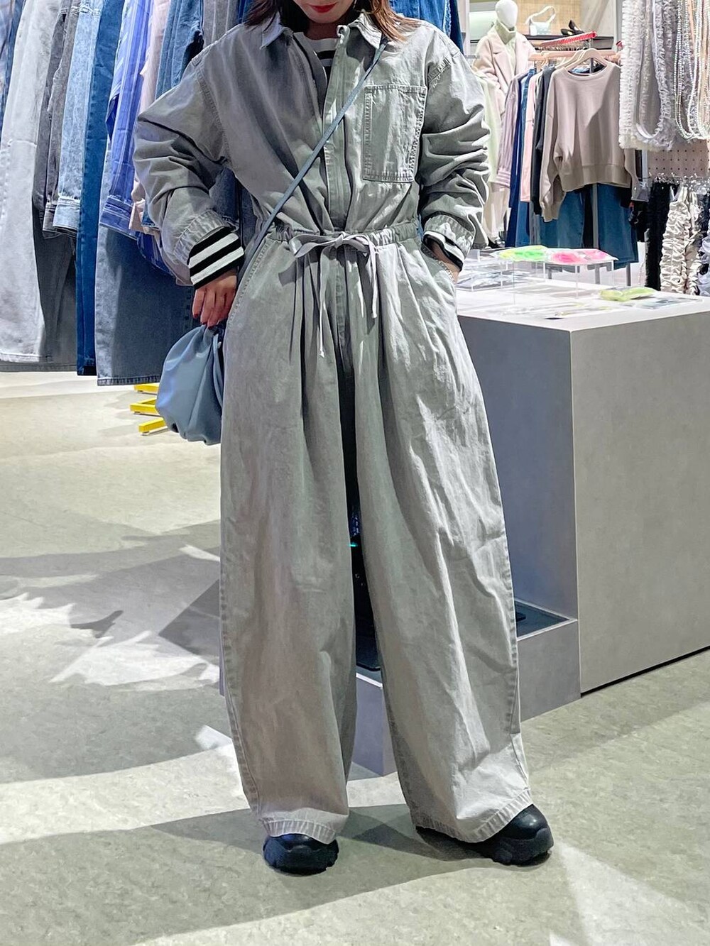 グレー系のつなぎ/オールインワン、ブルー系のショルダーバッグ、ブラック系のキャップを着用したレディースの冬コーディネートの2枚目の写真