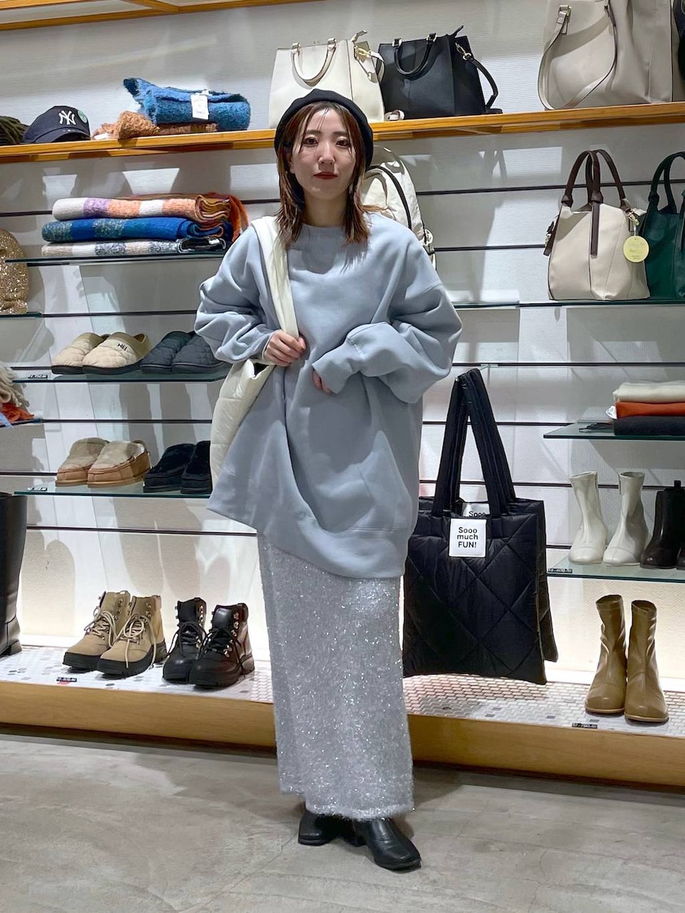 ホワイト系のトートバッグ、シルバー系のスカート、ブルー系のスウェットを着用したレディースの冬コーディネートの3枚目の写真