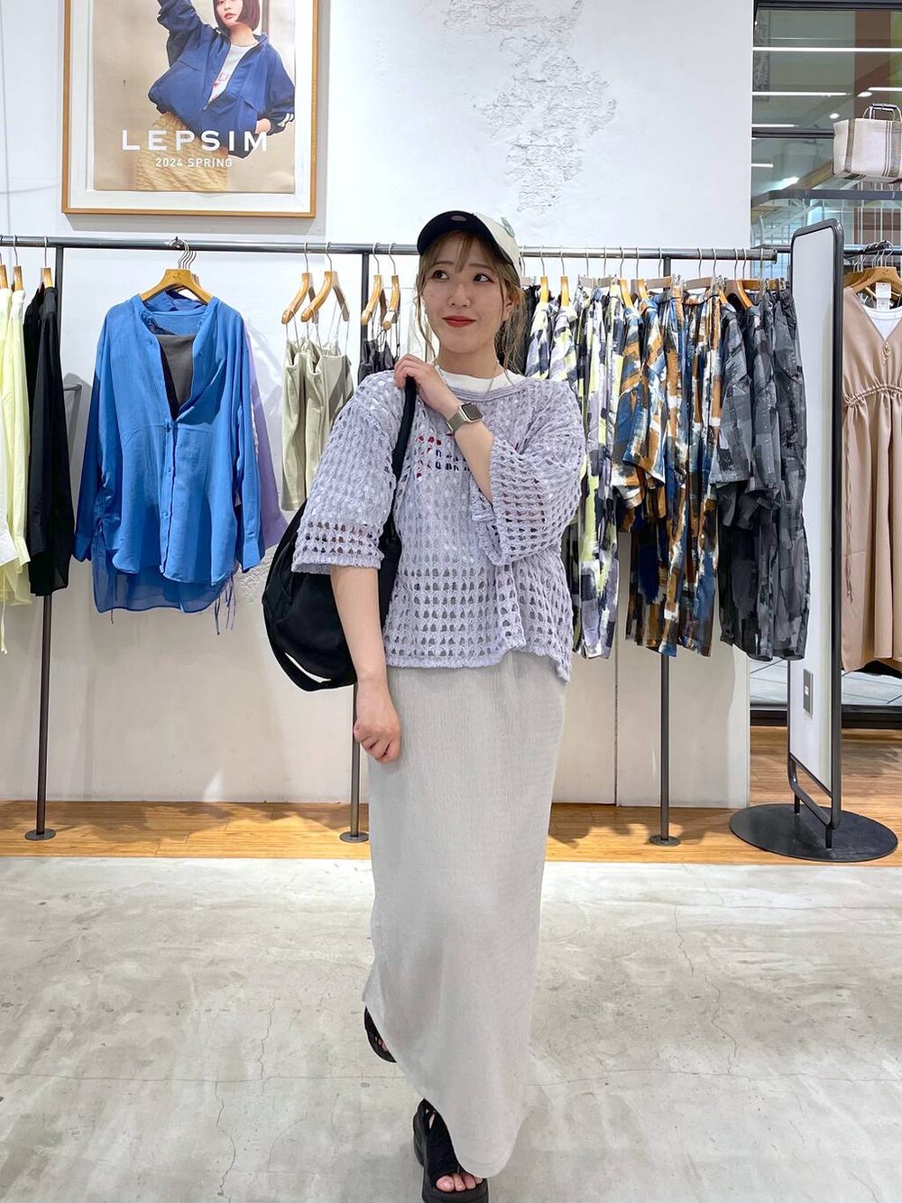 ブラック系のショルダーバッグ、グレー系のスカート、ホワイト系のTシャツ/カットソーを着用したレディースの春コーディネートの2枚目の写真