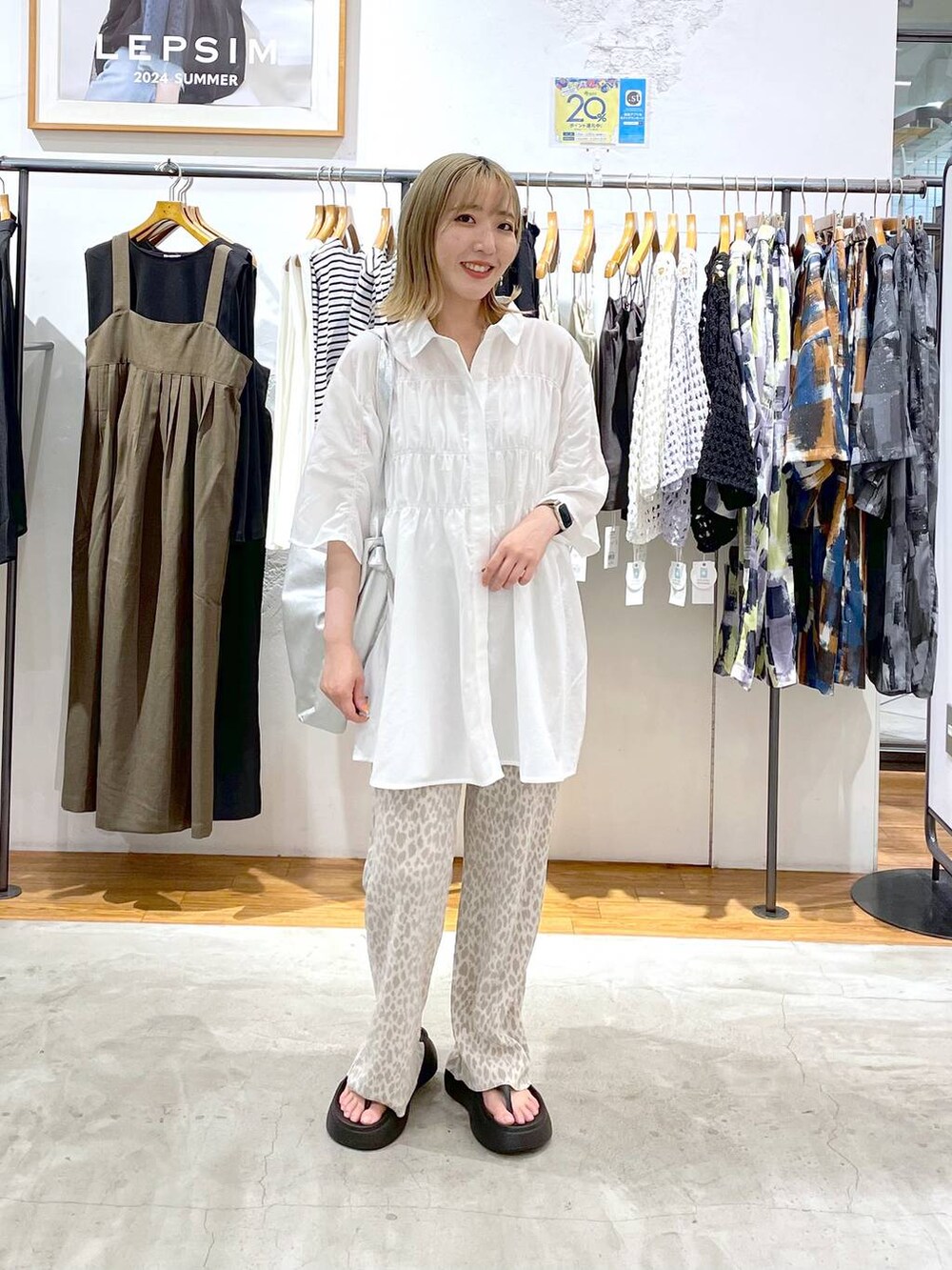 ブラック系のサンダル、シルバー系のトートバッグ、ホワイト系のシャツ/ブラウスを着用したレディースの夏コーディネートの3枚目の写真