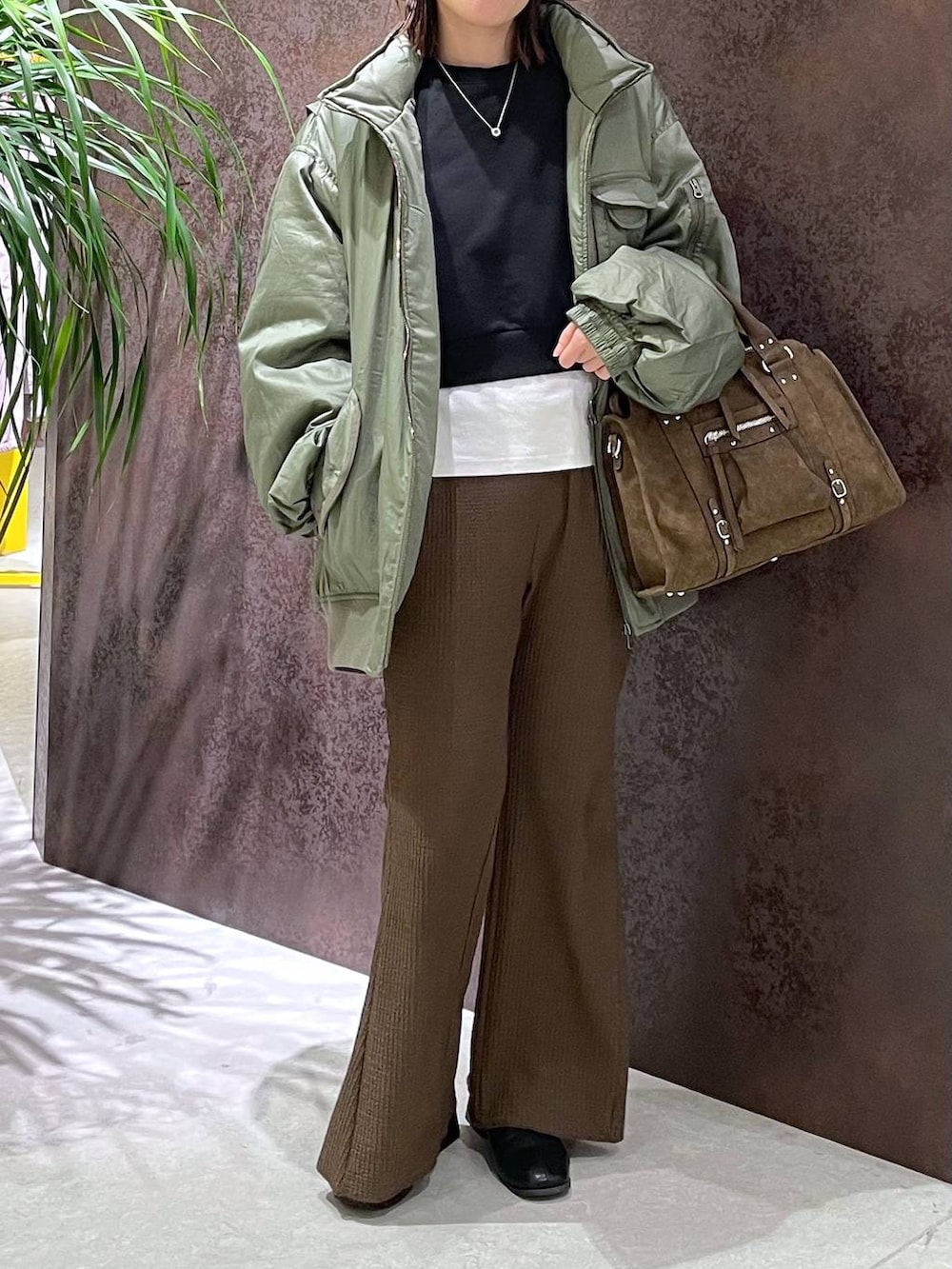 ブラウン系のボストンバッグ、ブラウン系のその他パンツ、グリーン系のブルゾンを着用したレディースの秋コーディネートの2枚目の写真