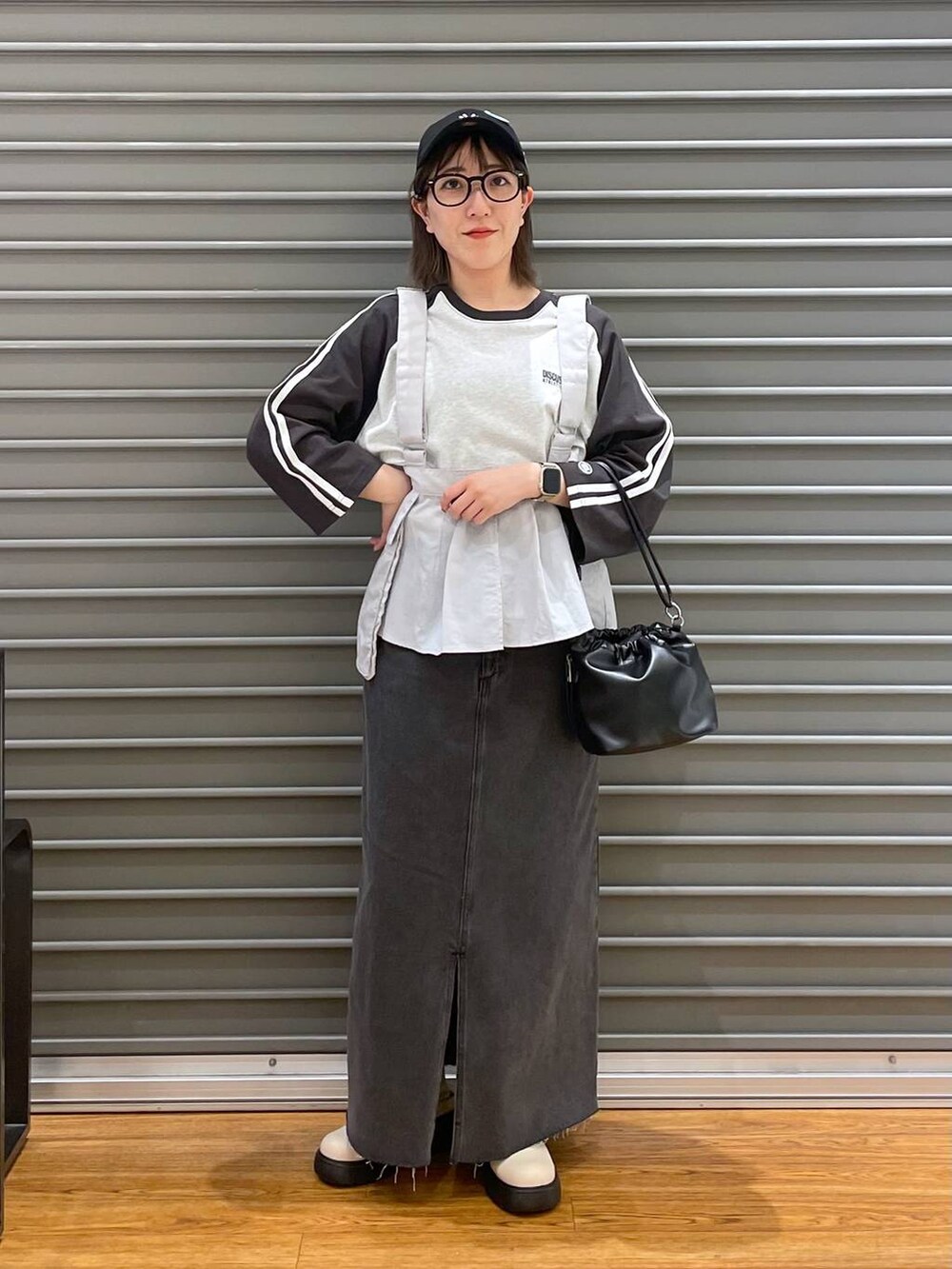 ブラック系のショルダーバッグ、ブラック系のTシャツ/カットソー、ブラック系のスカートを着用したレディースの春コーディネートの3枚目の写真