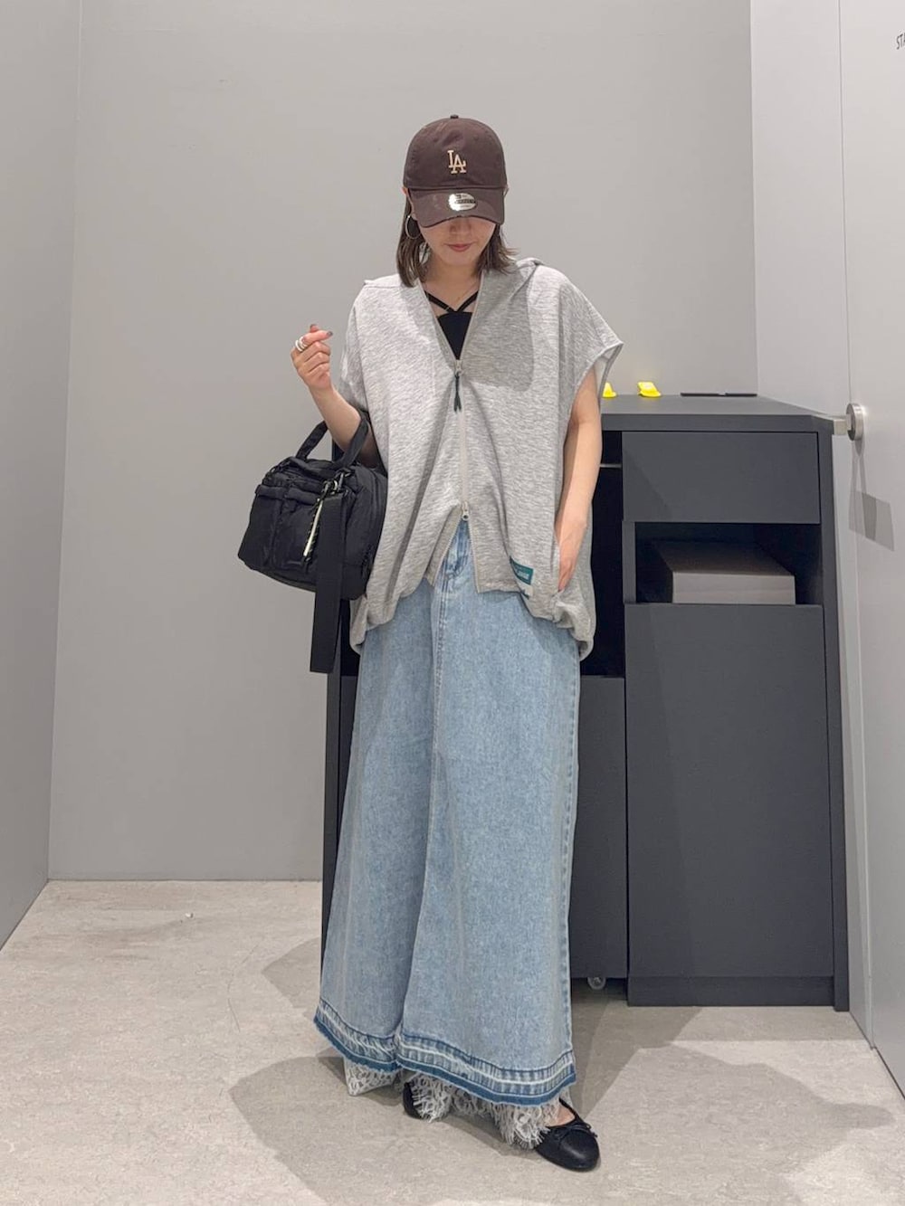 ブルー系のデニムスカート、その他のベスト、ブラック系のボストンバッグを着用したレディースの夏コーディネートの2枚目の写真