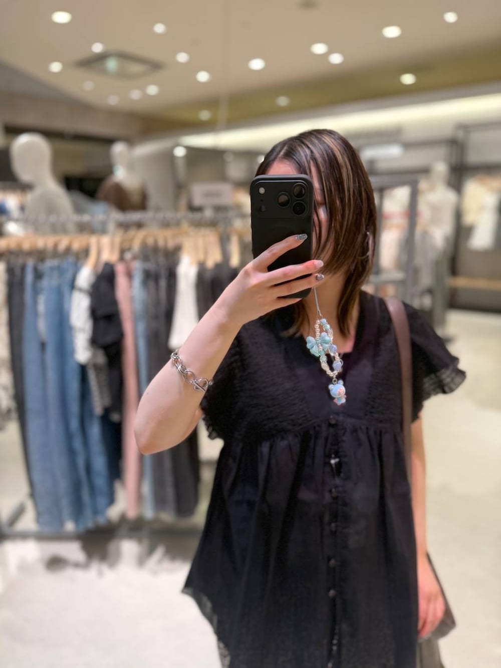 ブラック系のタンクトップ、ホワイト系のその他パンツ、ブラウン系のショルダーバッグを着用したレディースの夏コーディネートの4枚目の写真
