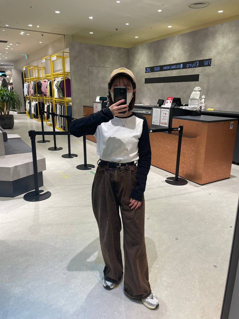 ブラウン系のデニムパンツ、ブラック系のTシャツ/カットソー、ブラック系のベルトを着用したレディースの秋コーディネートの3枚目の写真