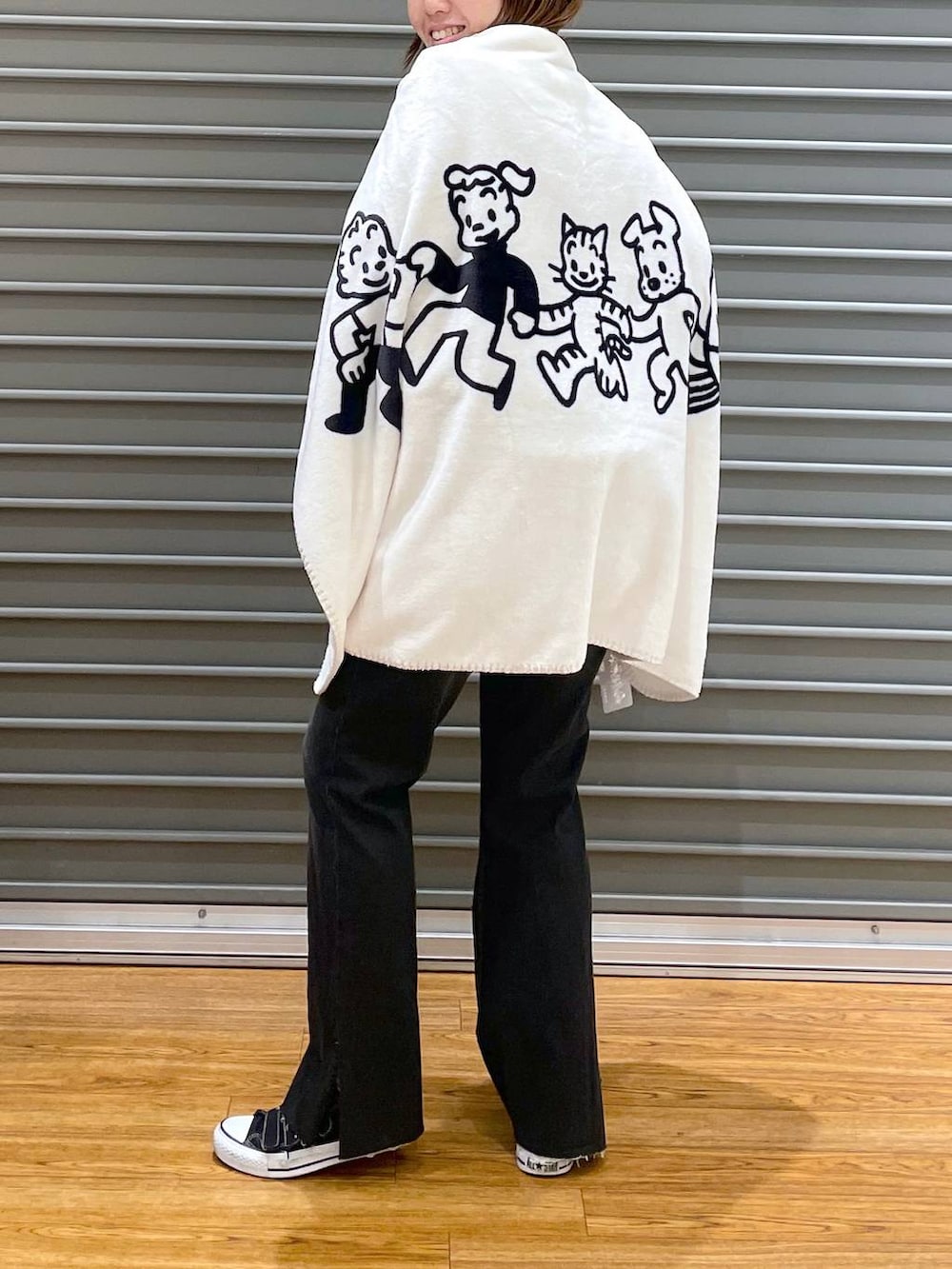 ブラック系のデニムパンツ、グレー系のニット/セーター、ホワイト系のブランケットを着用したレディースの冬コーディネートの4枚目の写真