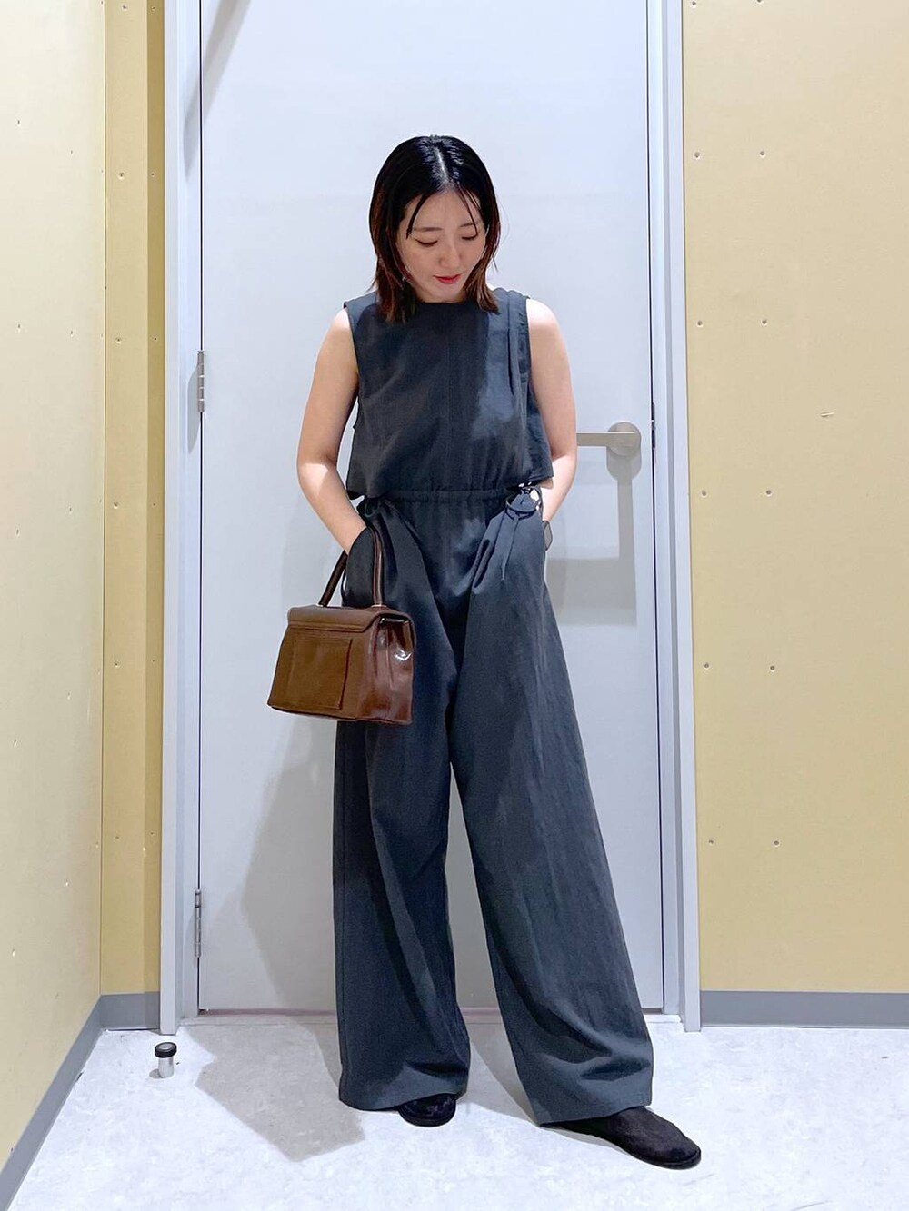 グレー系のサロペット/オーバーオール、ブラウン系のボストンバッグを着用したレディースの夏コーディネートの2枚目の写真