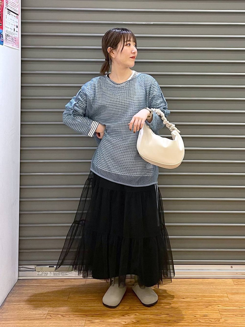 ブラック系のスカート、ホワイト系のショルダーバッグ、ホワイト系のTシャツ/カットソーを着用したレディースの春コーディネートの2枚目の写真