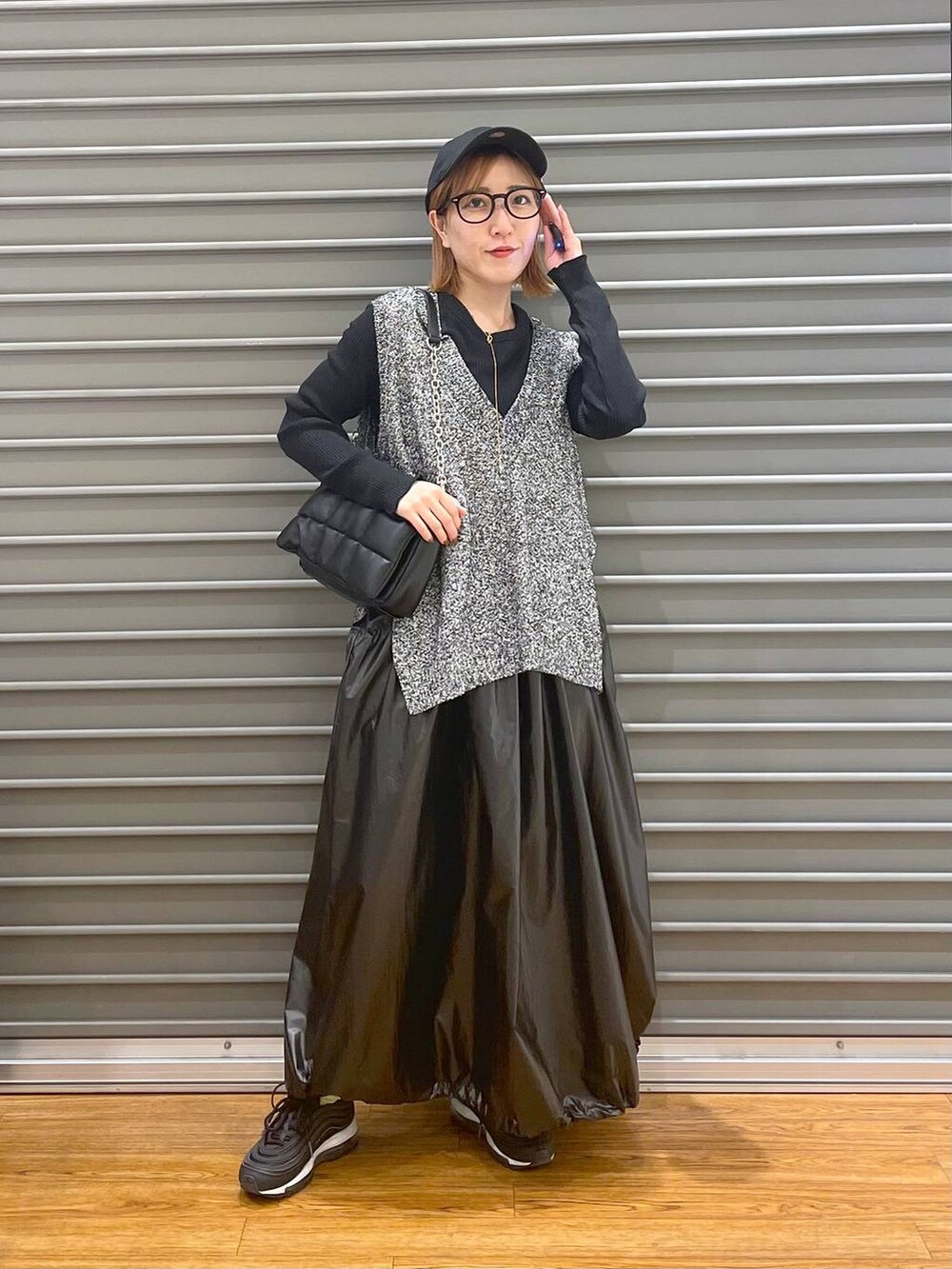 ブラック系のショルダーバッグ、ブラック系のベスト、ブラック系のTシャツ/カットソーを着用したレディースの春コーディネートの3枚目の写真