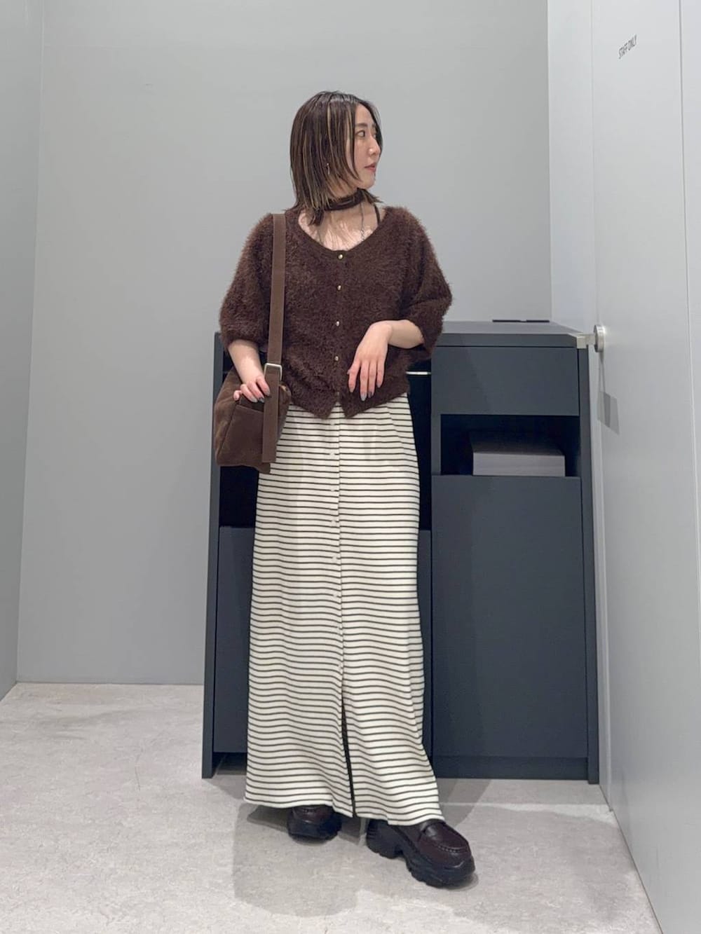 ブラウン系のカーディガン/ボレロ、ホワイト系のスカート、ブラウン系のローファーを着用したレディースの夏コーディネートの2枚目の写真