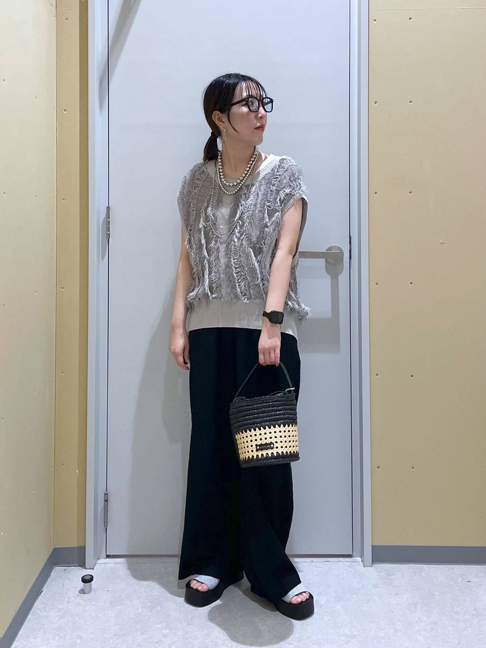 シルバー系のサンダル、ブラック系のショルダーバッグ、グレー系のニット/セーターを着用したレディースの夏コーディネートの3枚目の写真