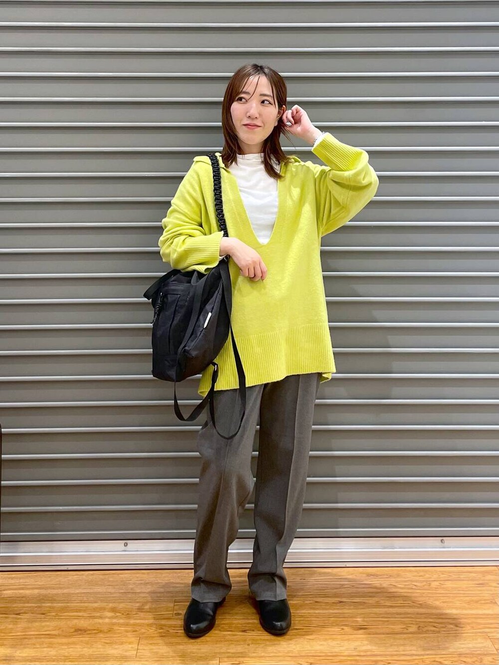 グレー系のその他パンツ、ホワイト系のTシャツ/カットソー、ブラック系のショルダーバッグを着用したレディースの冬コーディネートの2枚目の写真