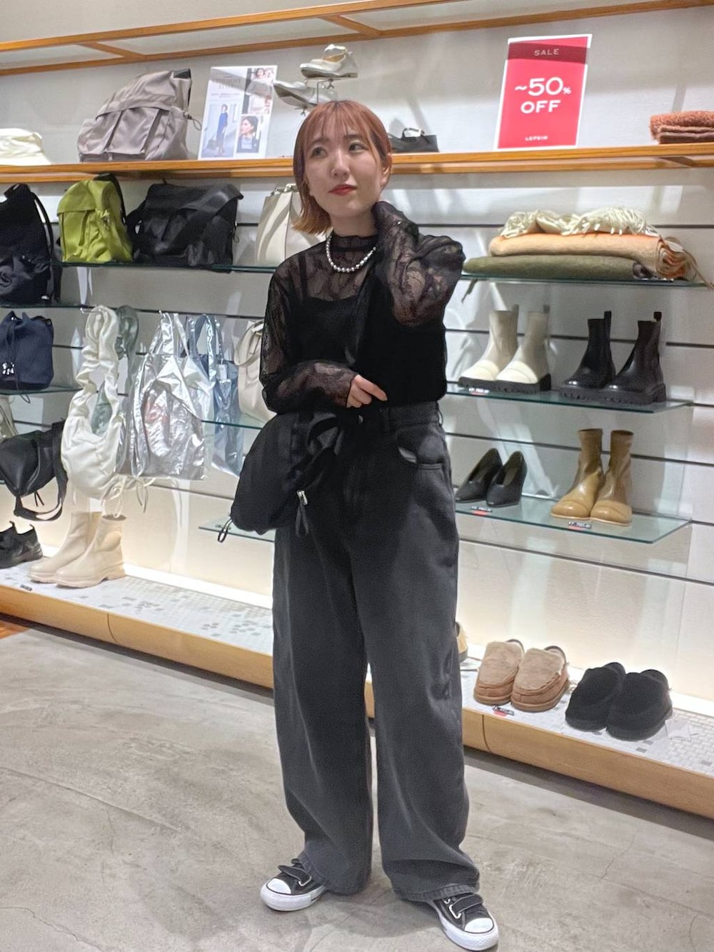 ブラック系のシャツ/ブラウス、ブラック系のデニムパンツ、ブラック系のショルダーバッグを着用したレディースの冬コーディネートの2枚目の写真