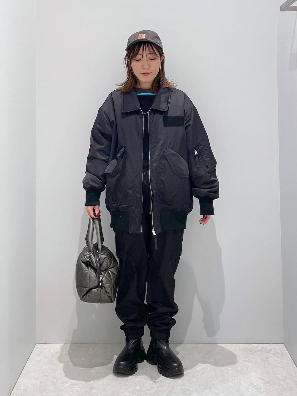 ブラック系のブルゾン、ブラック系のトートバッグ、ブラック系のカーゴパンツを着用したレディースの冬コーディネートの5枚目の写真