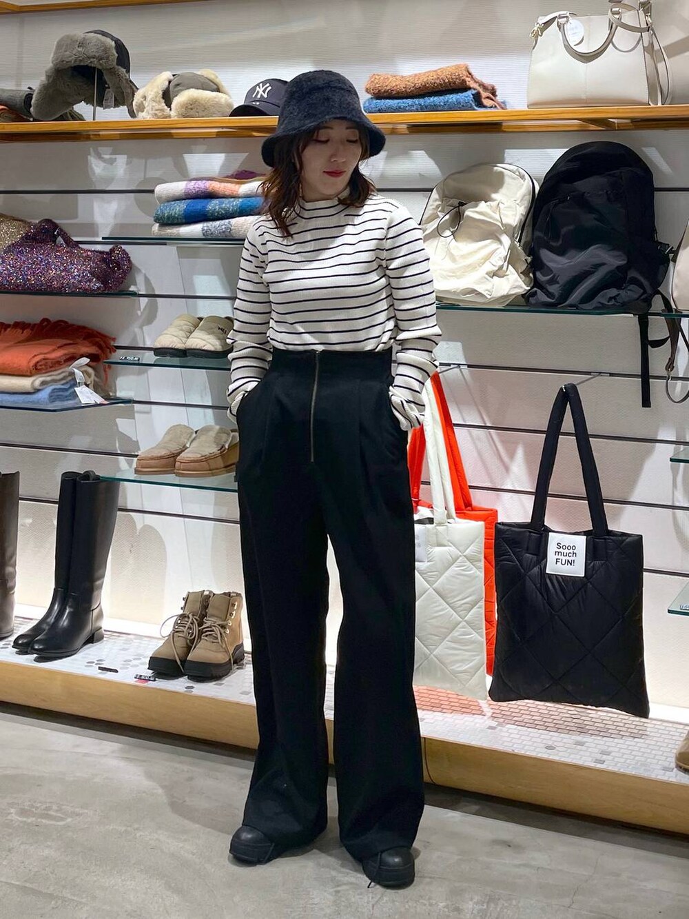 ホワイト系のニット/セーター、ブラック系のブーツ、ブラック系のその他パンツを着用したレディースの冬コーディネートの2枚目の写真