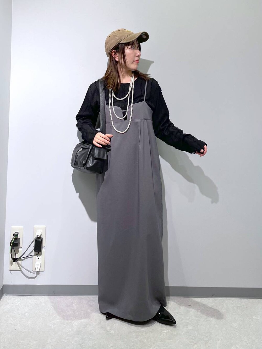 ブラック系のTシャツ/カットソー、ブラック系のショルダーバッグ、ブラック系のパンプスを着用したレディースの春コーディネートの2枚目の写真