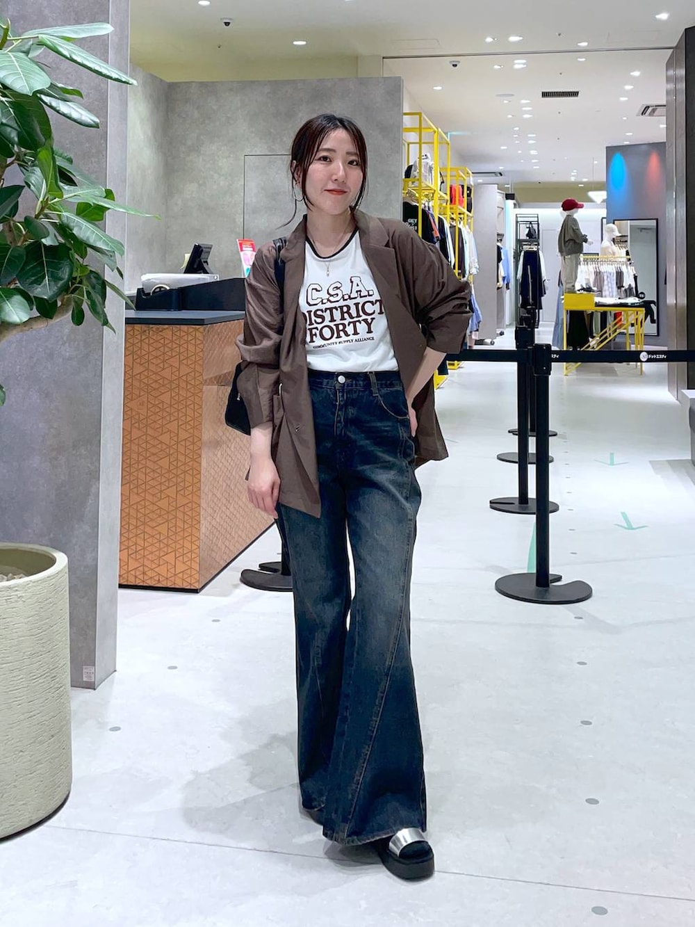 ブルー系のデニムパンツ、シルバー系のサンダル、グリーン系のテーラードジャケットを着用したレディースの春コーディネートの2枚目の写真