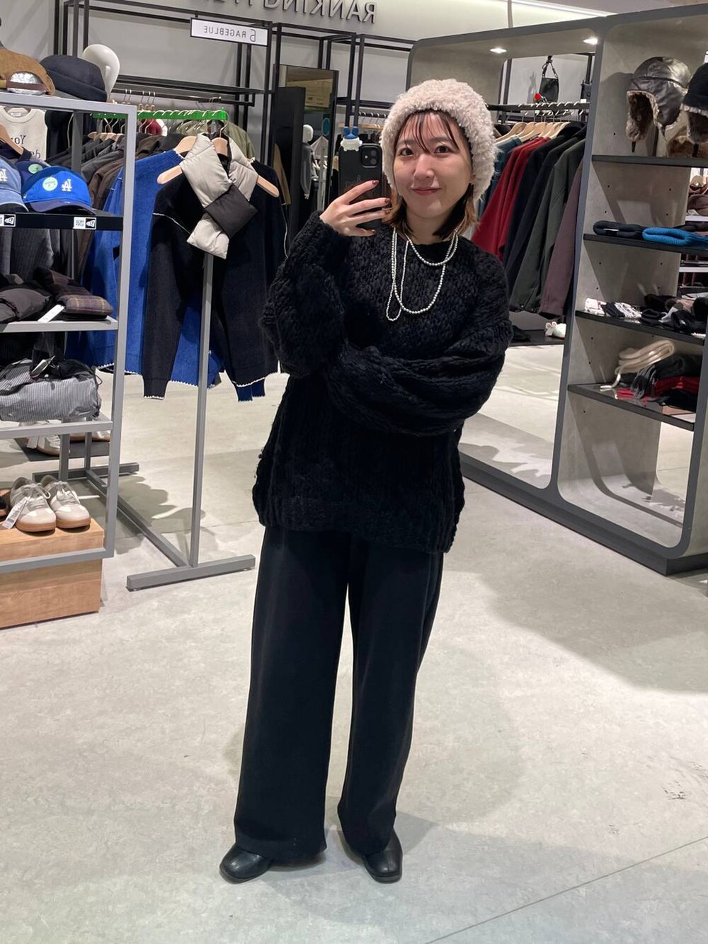 ブラック系のブルゾン、ブラック系のスウェットパンツ、ホワイト系のニット/セーターを着用したレディースの冬コーディネートの2枚目の写真