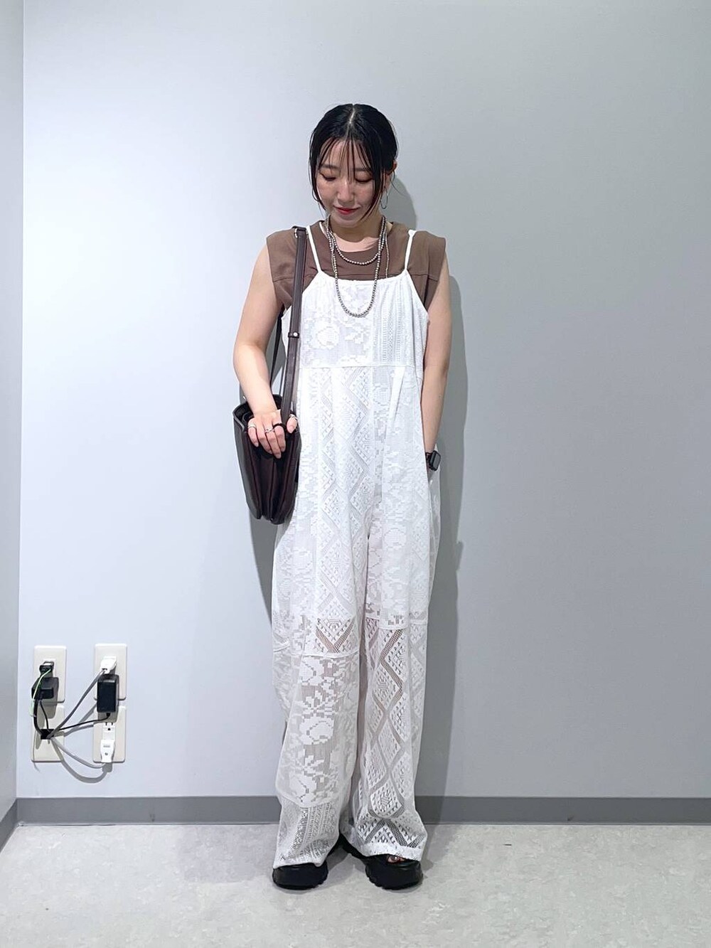 ブラック系のサンダル、ベージュ系のサロペット/オーバーオール、ブラウン系のショルダーバッグを着用したレディースの夏コーディネートの3枚目の写真